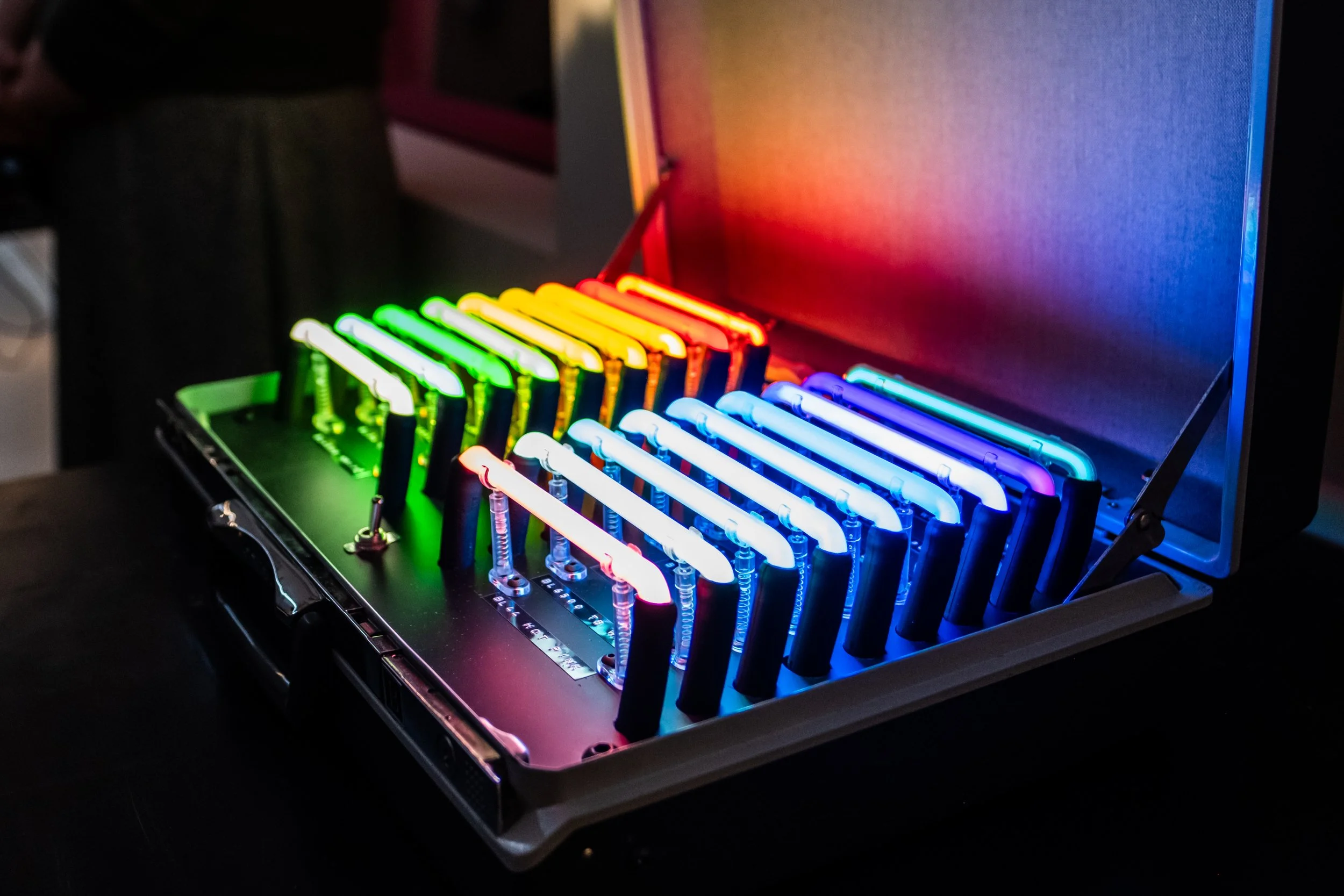 A open briefcase featuring lines of neon in different colors.