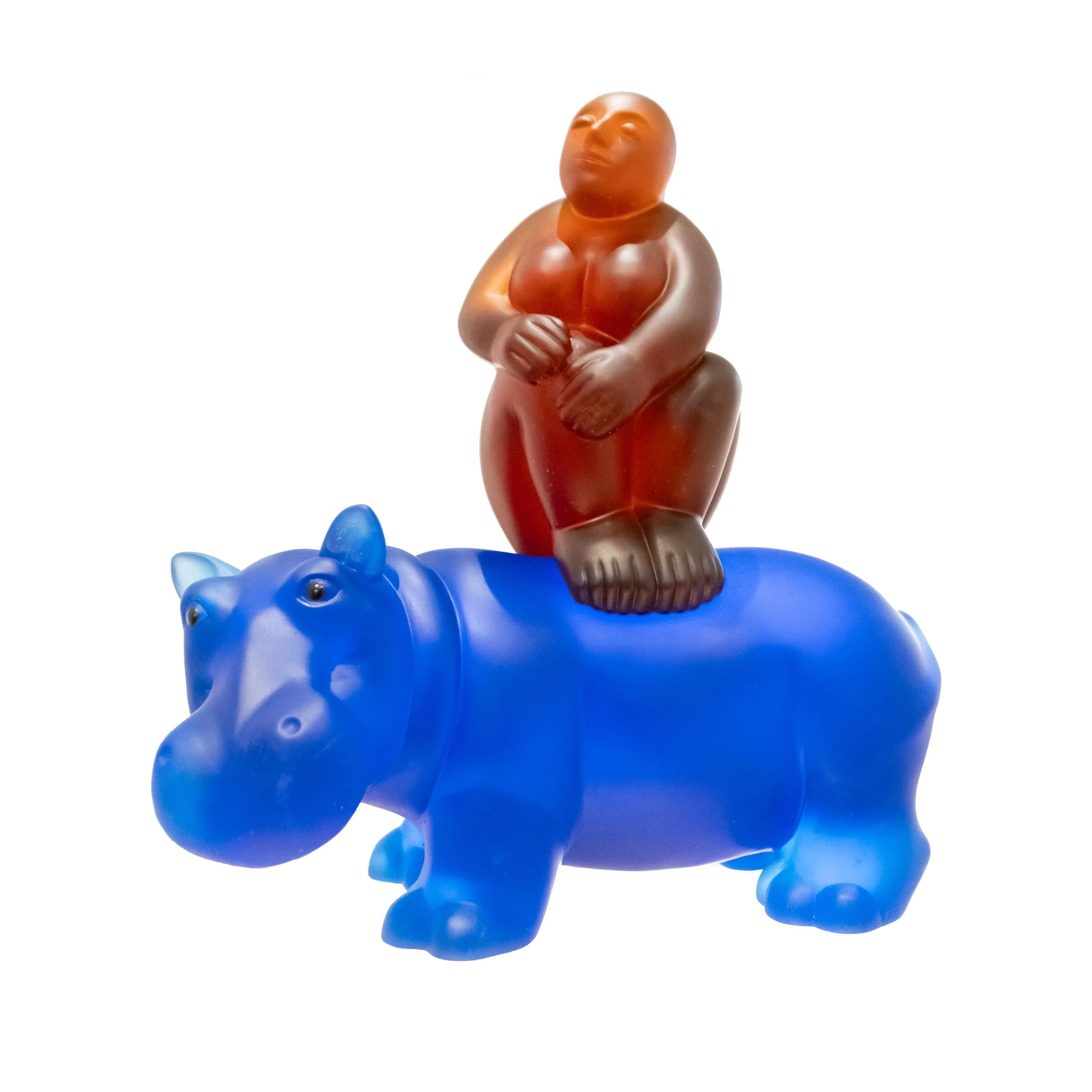 A glass amber female figure sitting on top of a blue hippo.