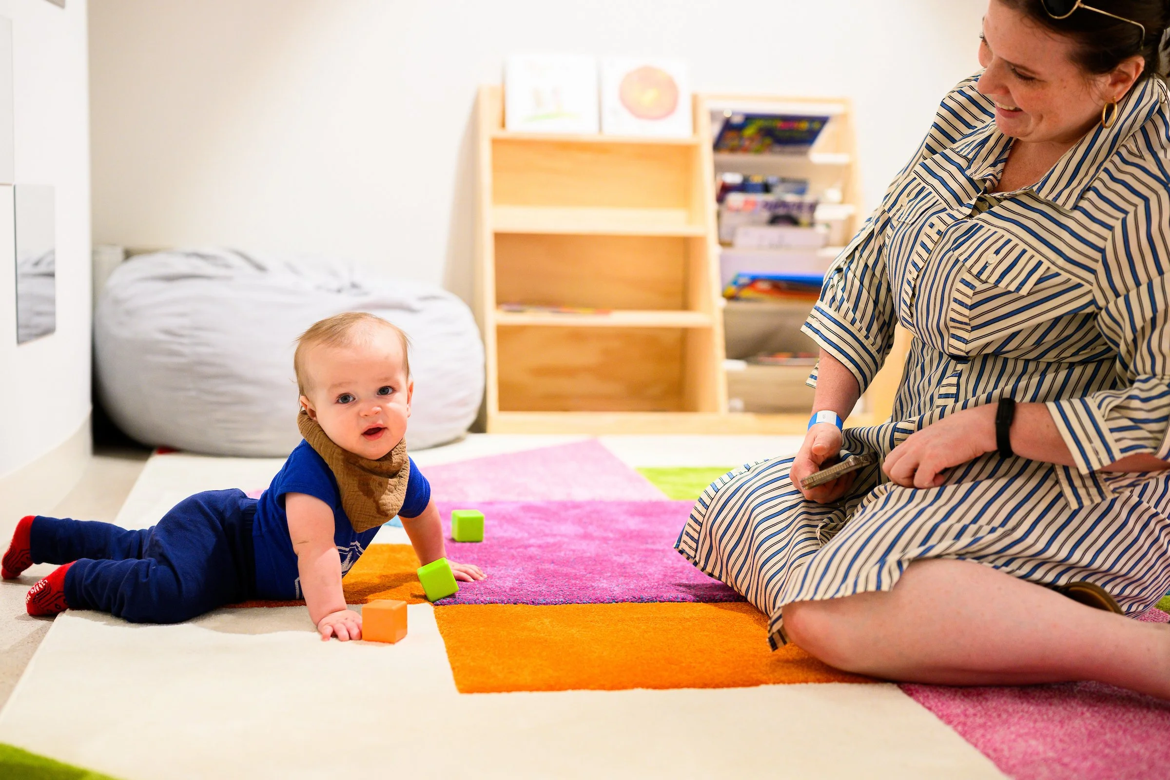 A baby pushing himself up off a soft rug.