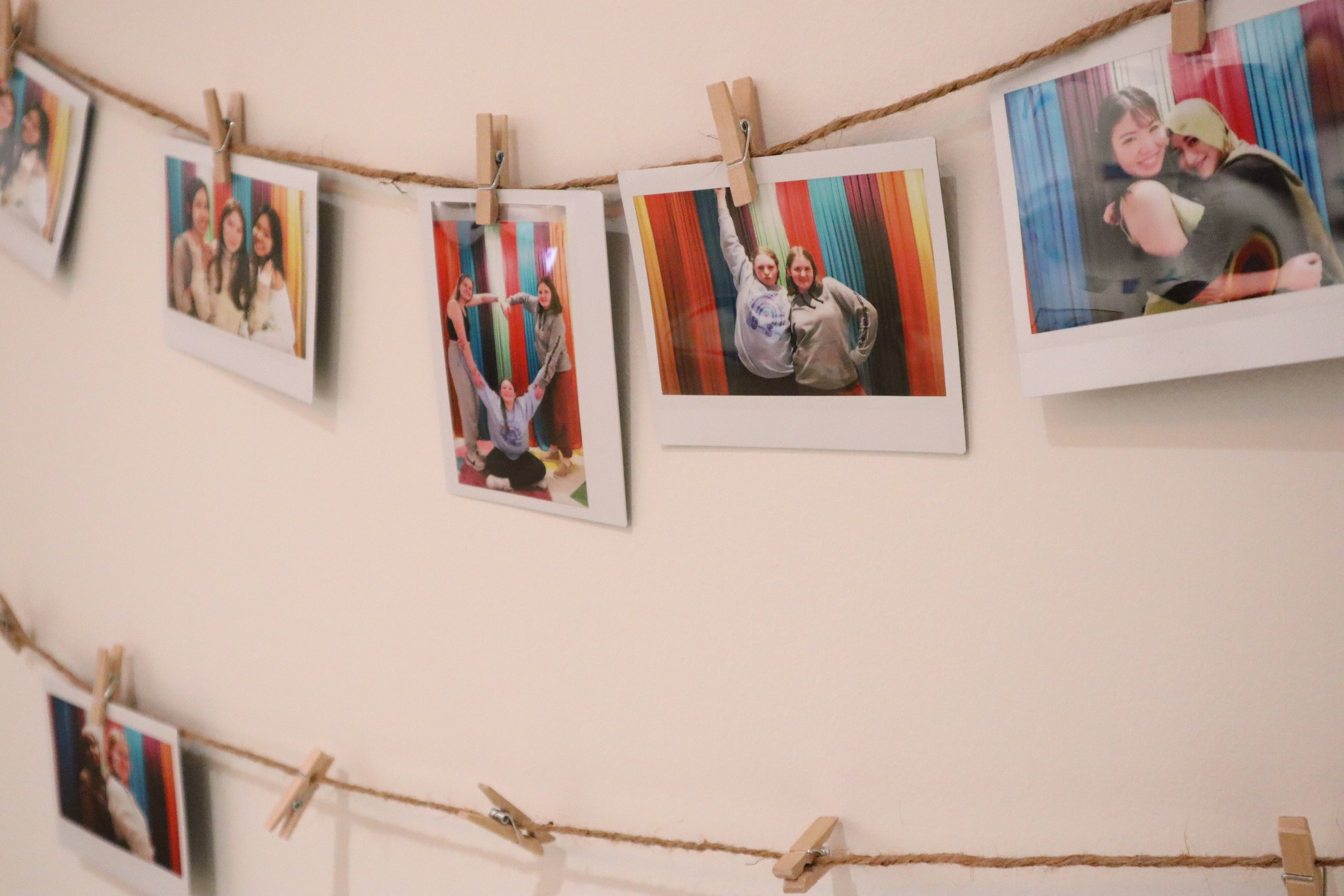 Polaroid portraits of teenagers strung up on lines of twine with mini clothespins.