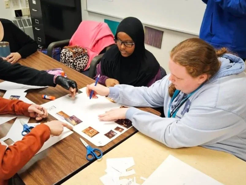 High school students seated at a table in their classroom working on a project inspired by artwork from the museum.