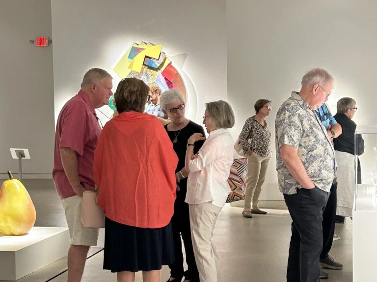 Visitors chatting with each other in the gallery.
