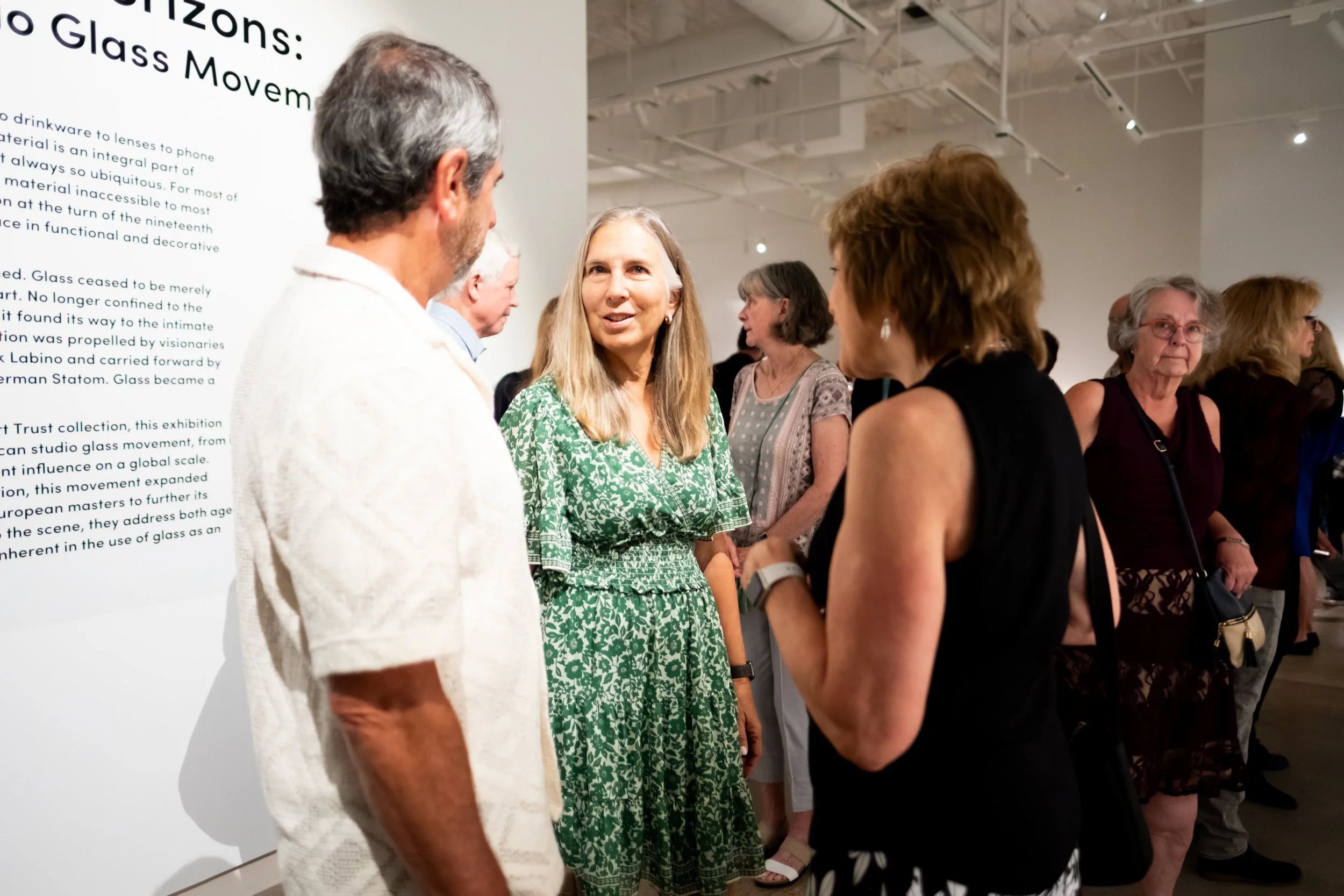 People gather and converse at the entrance of the exhibition. 