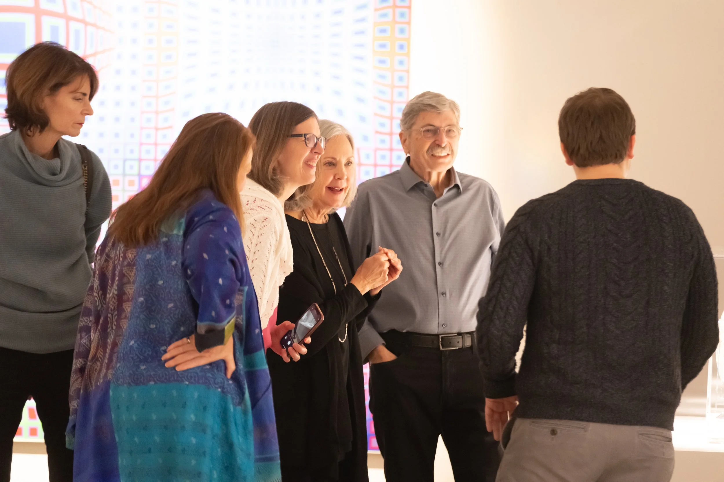 A group of people converse in the gallery. 