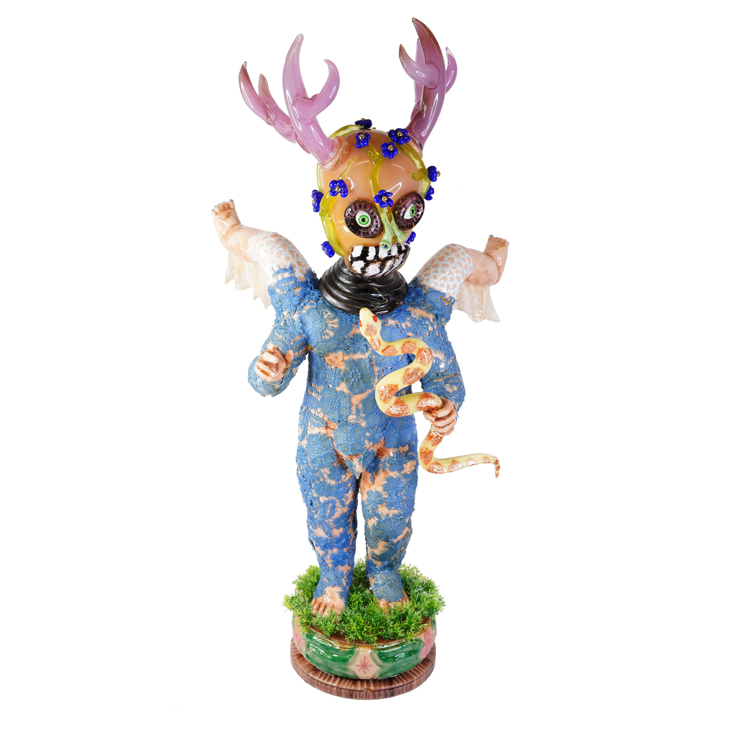 Sculpture of a human-like figure with antlers holding a snake, two legs protrude from its shoulders.