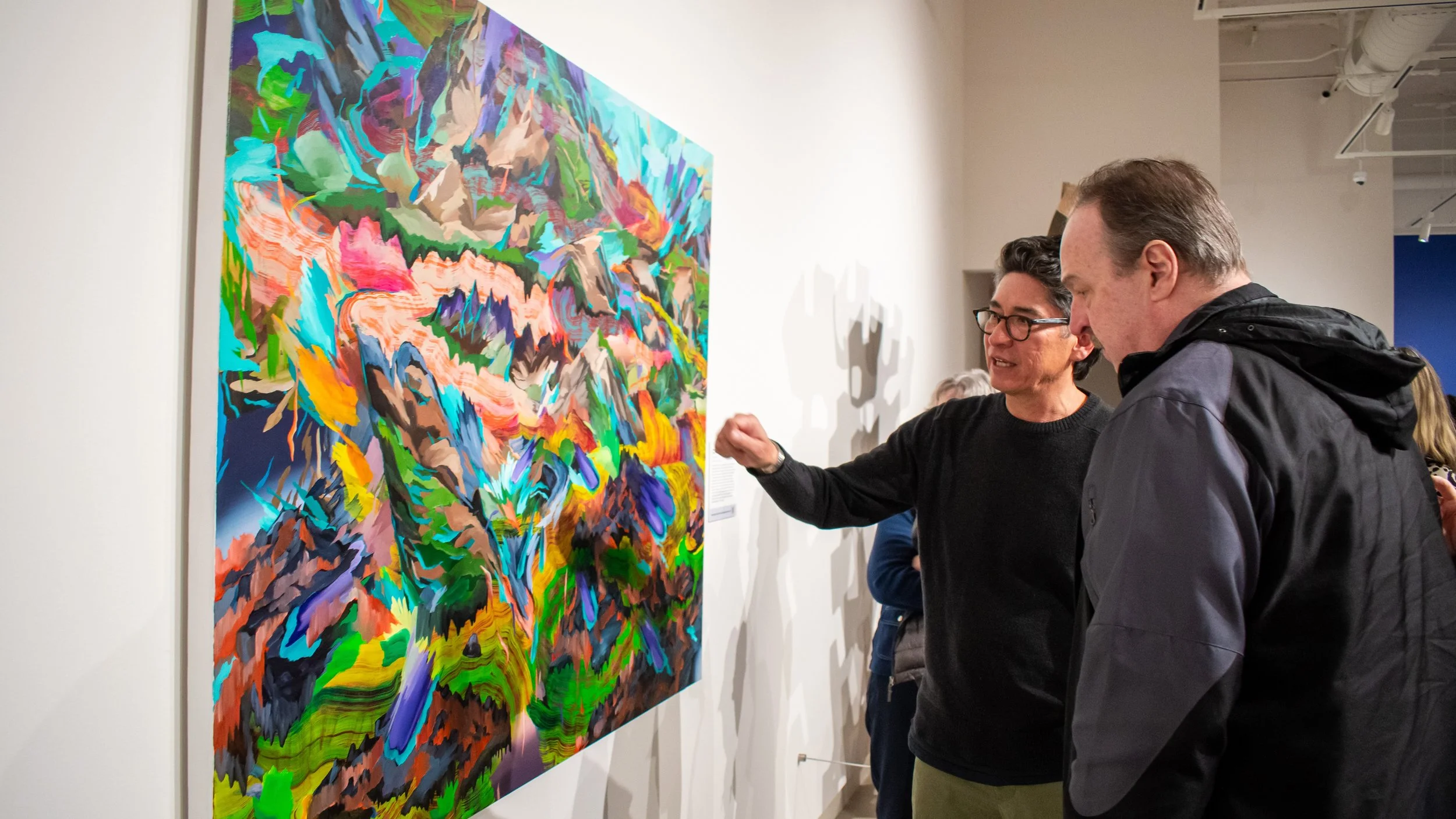 Artist Steven Yazzie discusses his painting with a visitor.jpg