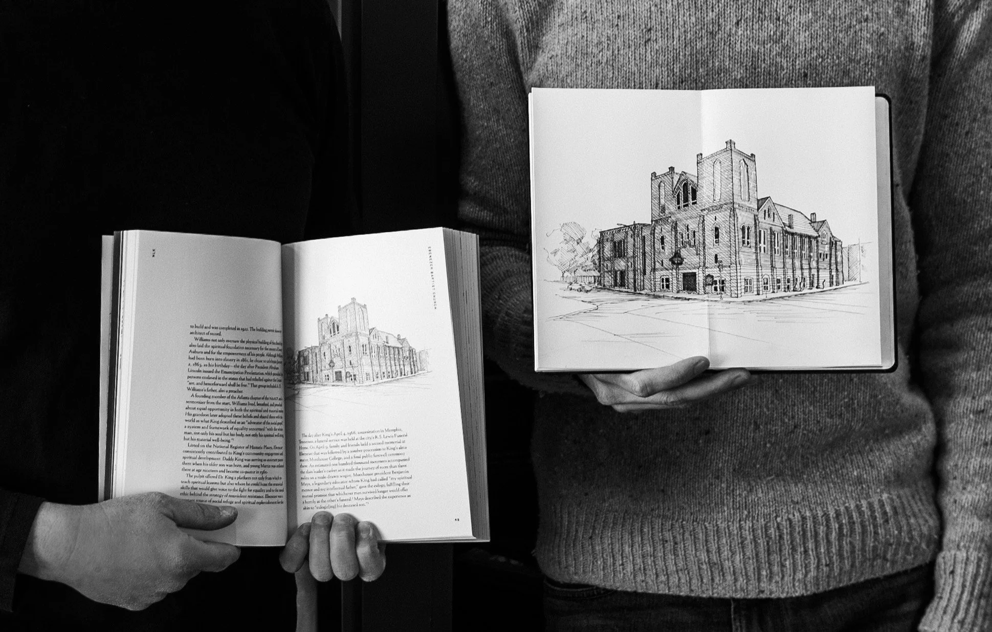 Person holding open book with architectural sketch of a church, and another person holding an open book with similar sketch, both seen from a top-down view.