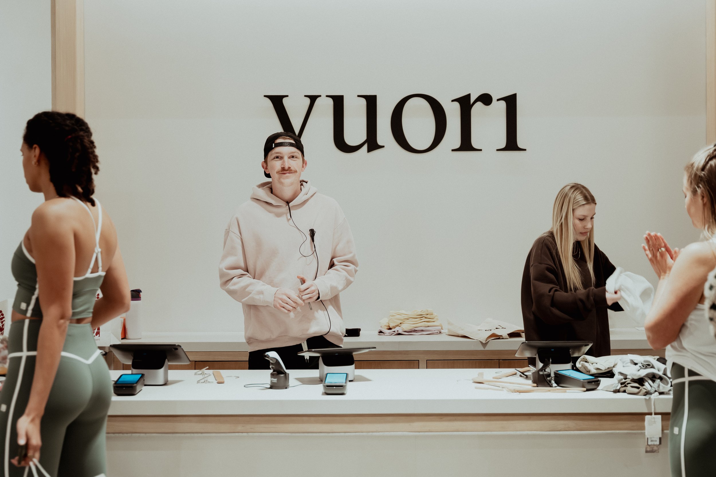 People shopping at the Apple Store, with the store's name reversed on the wall behind them.