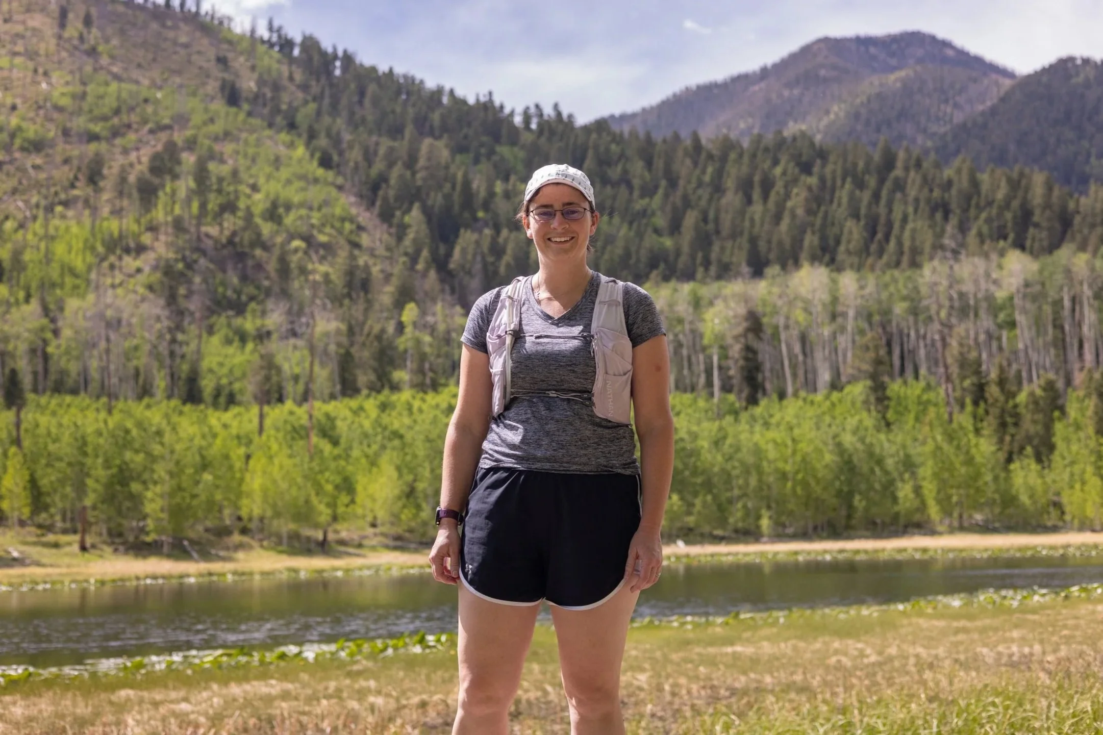 Riannon posing in front of a mountain lake