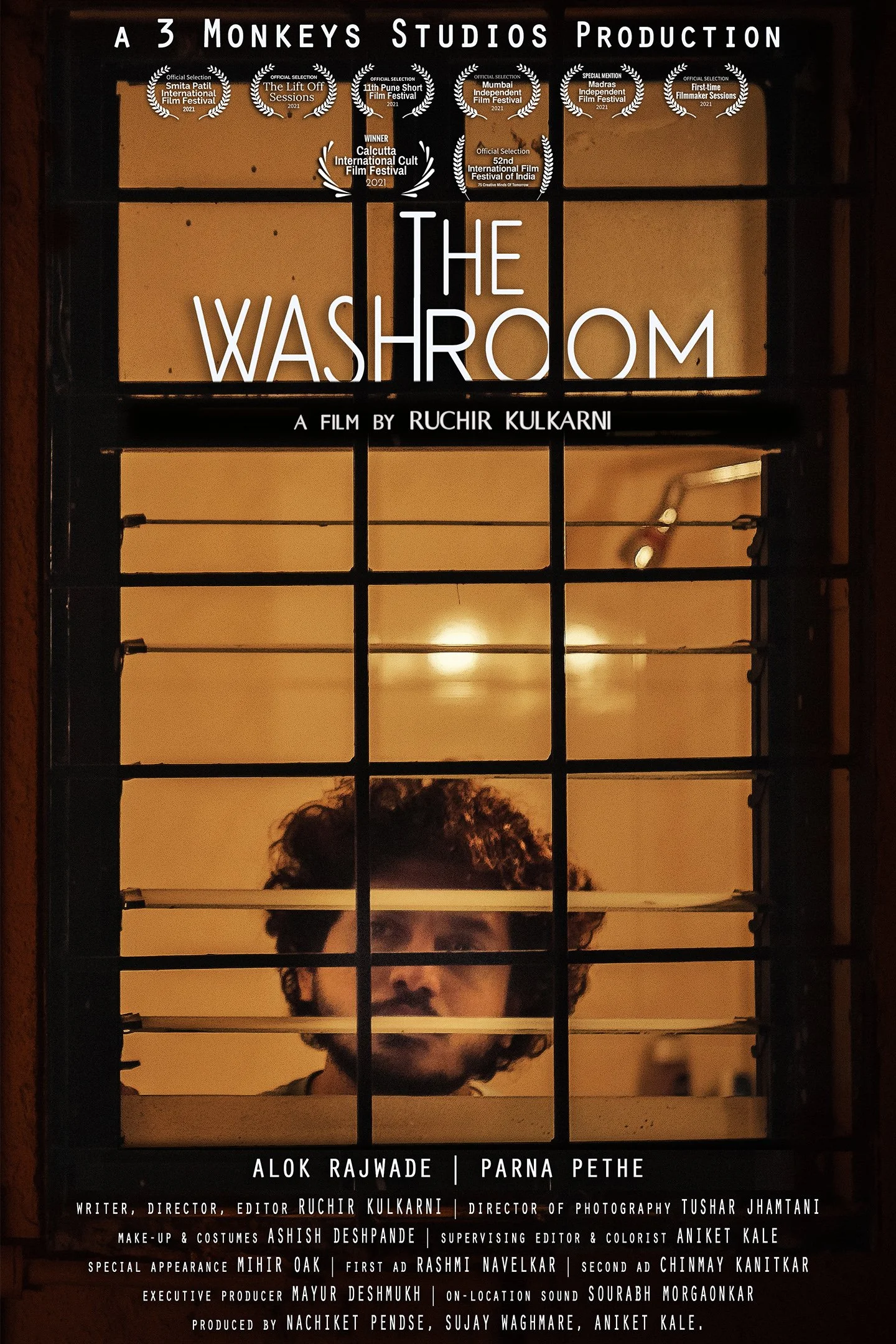 Poster for the film "The Washroom" featuring a man behind bars or a gate, with awards and film festival recognition at the top, and credits for cast and crew at the bottom.