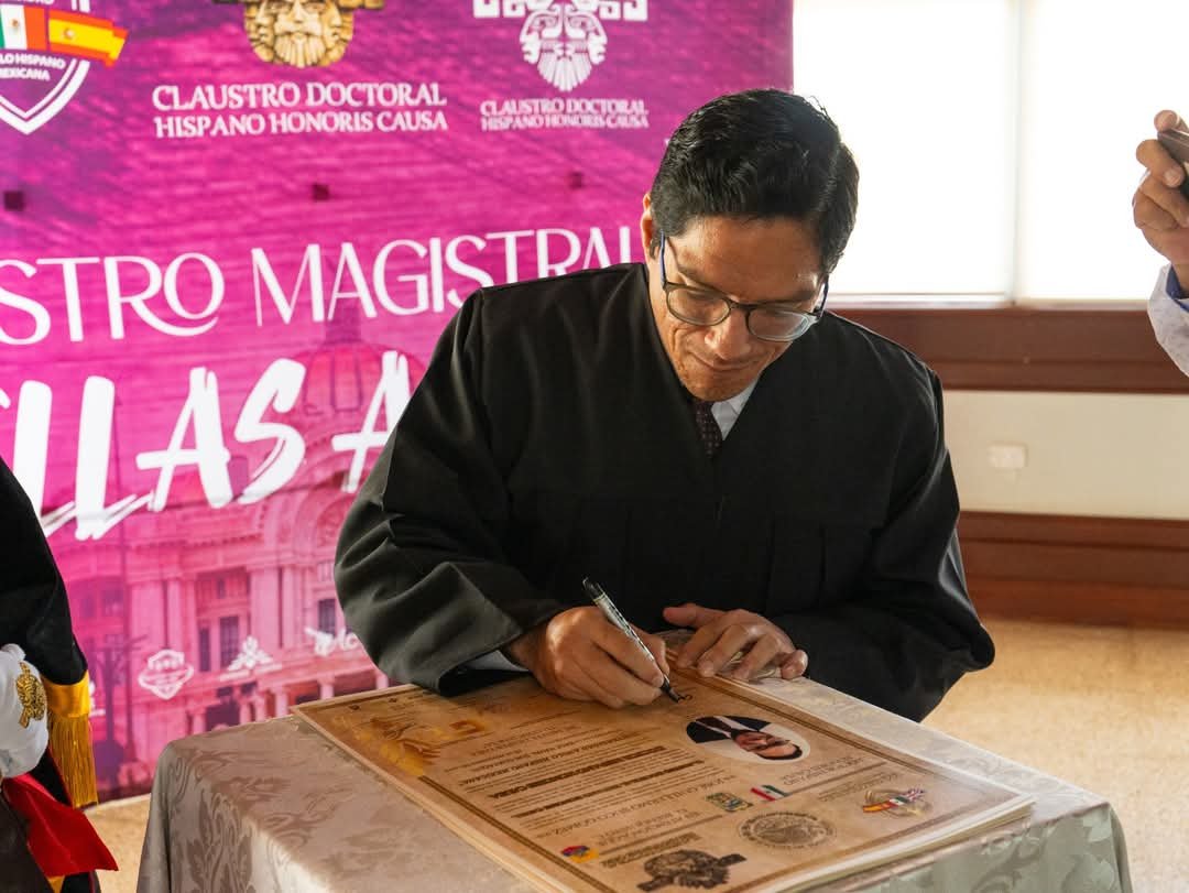 Guillermo Suco firmando su doctorado honoris causa