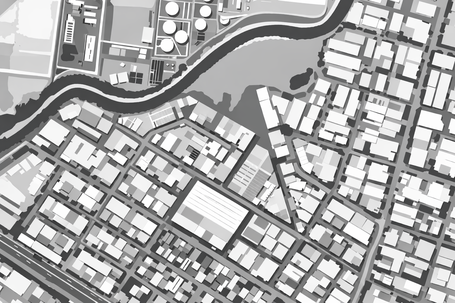 Black and white aerial map of an urban area with a river flowing through it, surrounded by buildings, streets, and open spaces.