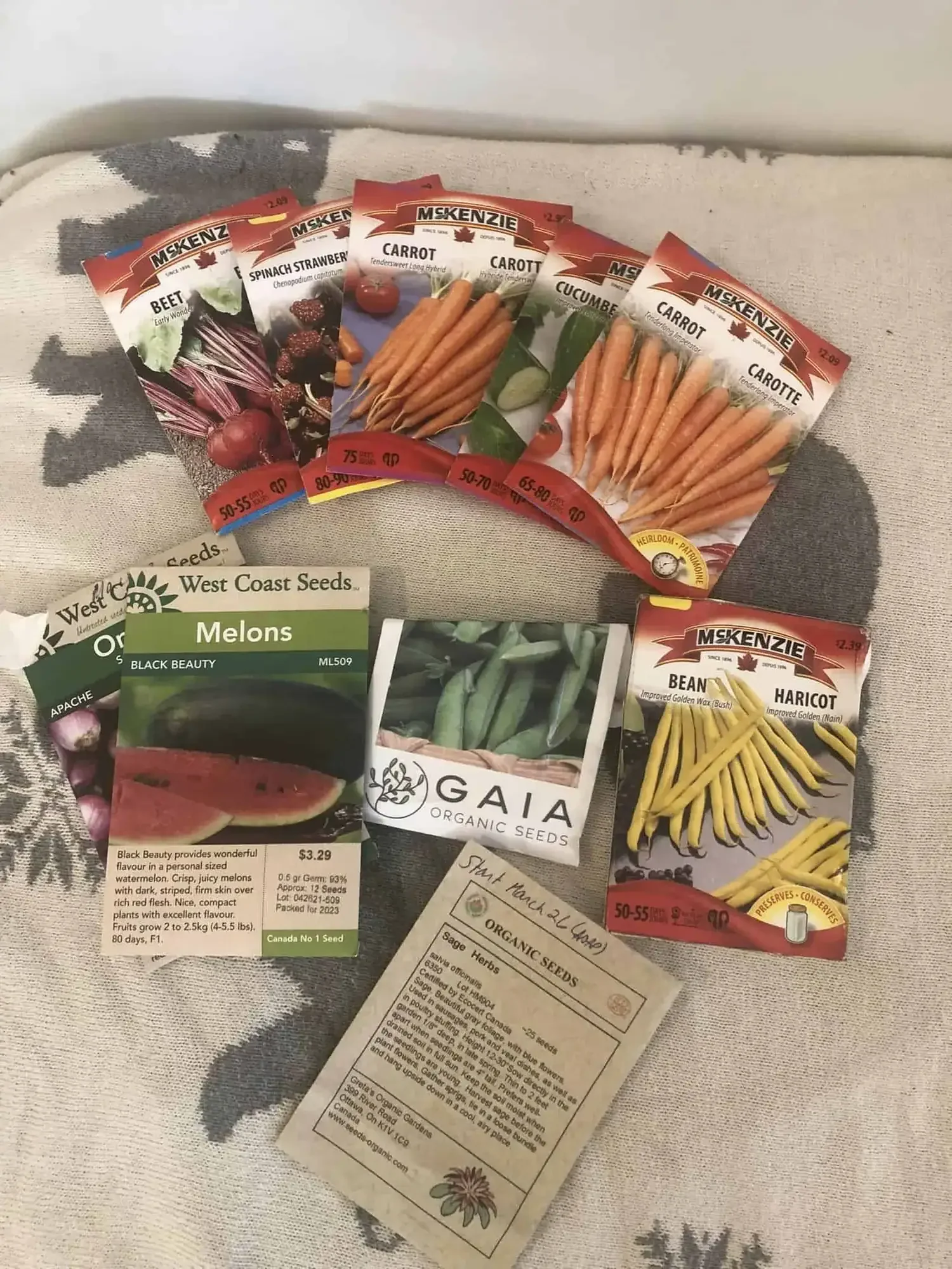 A table covered in many left over seeds like carrots and beets from a seed sharing event near Ottawa, Ontario.