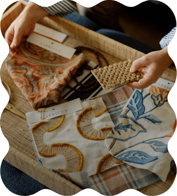 Person holding a swatch of woven fabric in a drawer filled with various fabric samples, swatches, and textiles.
