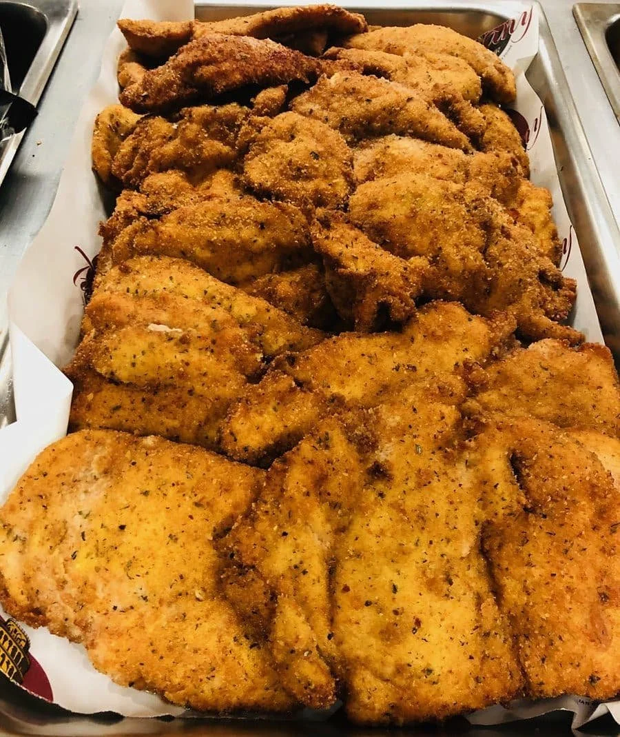 Basket of assorted fried chicken pieces, including breasts, wings, and thighs.