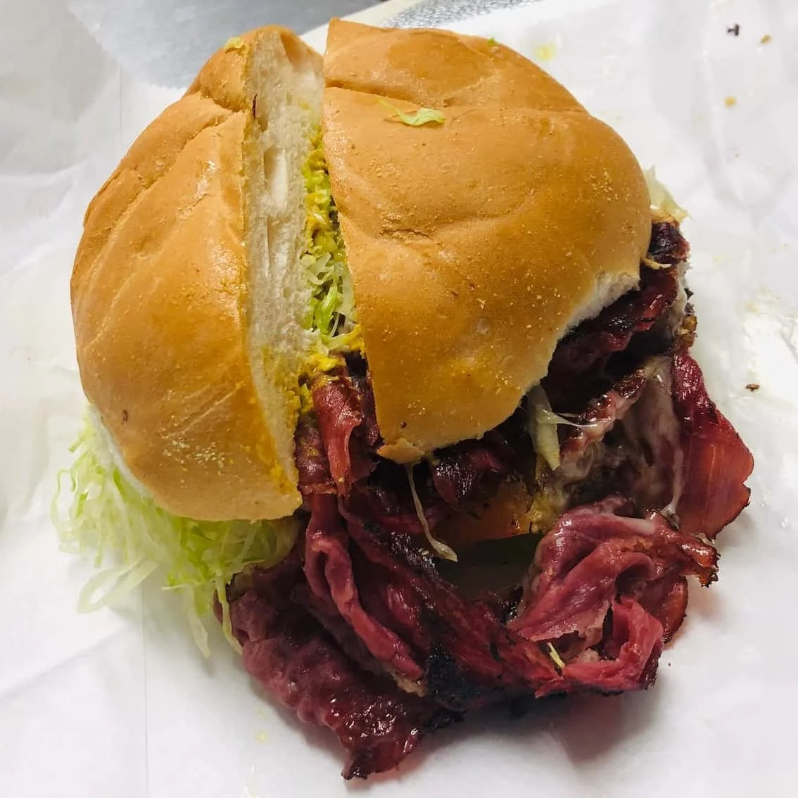 Barbecue sandwich with shredded beef or pork, lettuce, and bun.