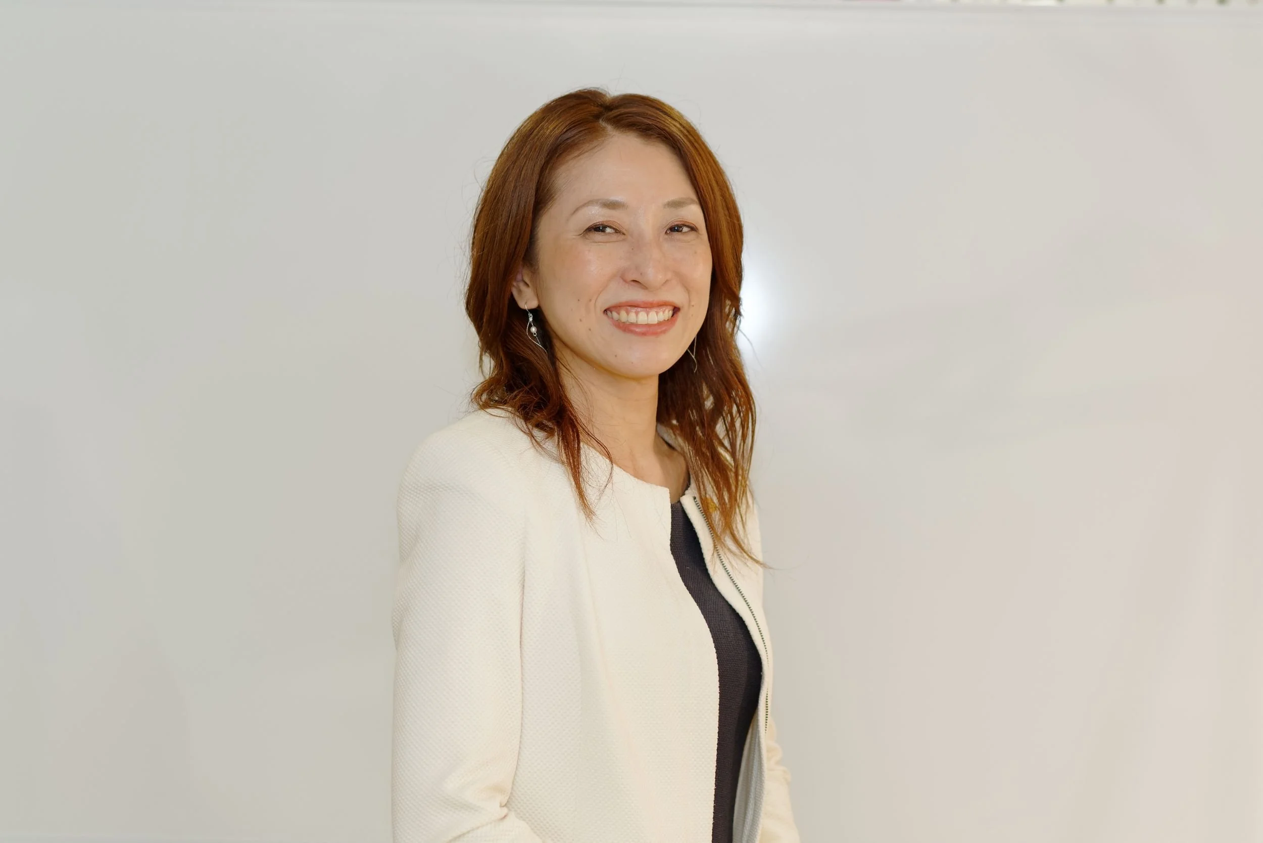 白いジャケットを着た笑顔の代表・木村亜矢氏