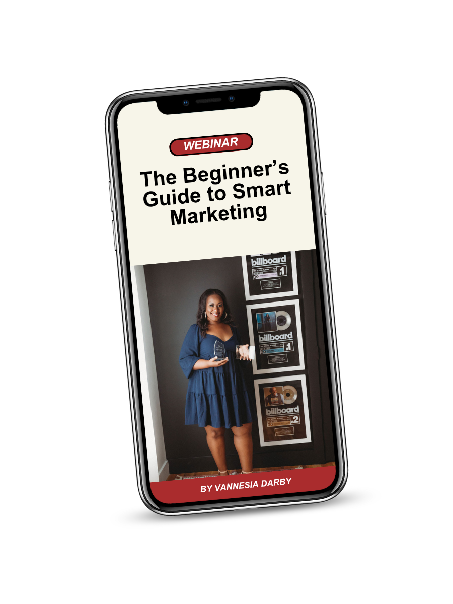 Smartphone screen displaying a webinar titled 'The Beginner's Guide to Smart Marketing' by Vanniesia Darby, with a woman standing next to framed Billboard awards.