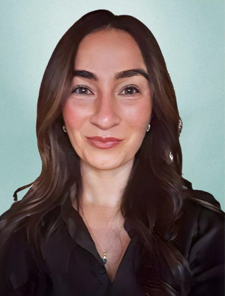A young woman with long brown hair, wearing a black top and pearl earrings, smiling at the camera against a light blue background. Alex Dominici, Alexandria Dominici, Alexandria Assentato.