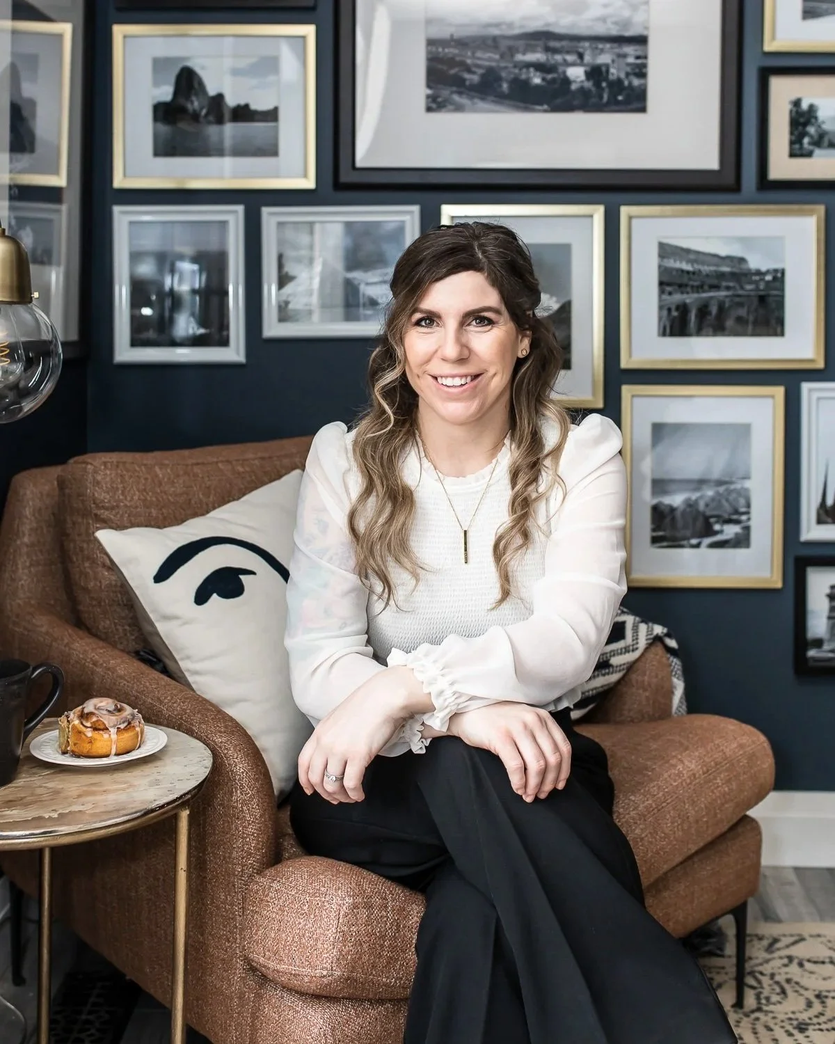 maggie venne headshot seated in front of navy blue gallery wall