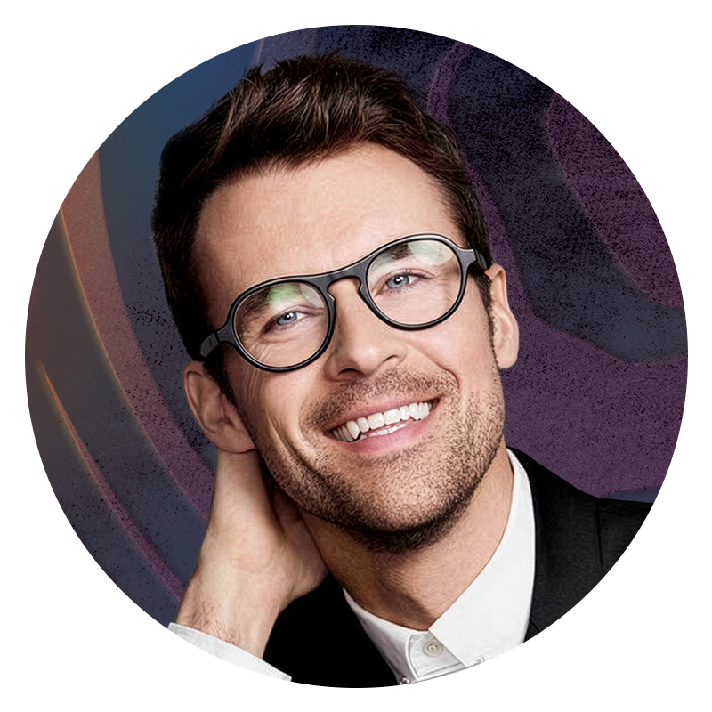 Headshot of Brad Goreski in black rimmed glasses, smiling