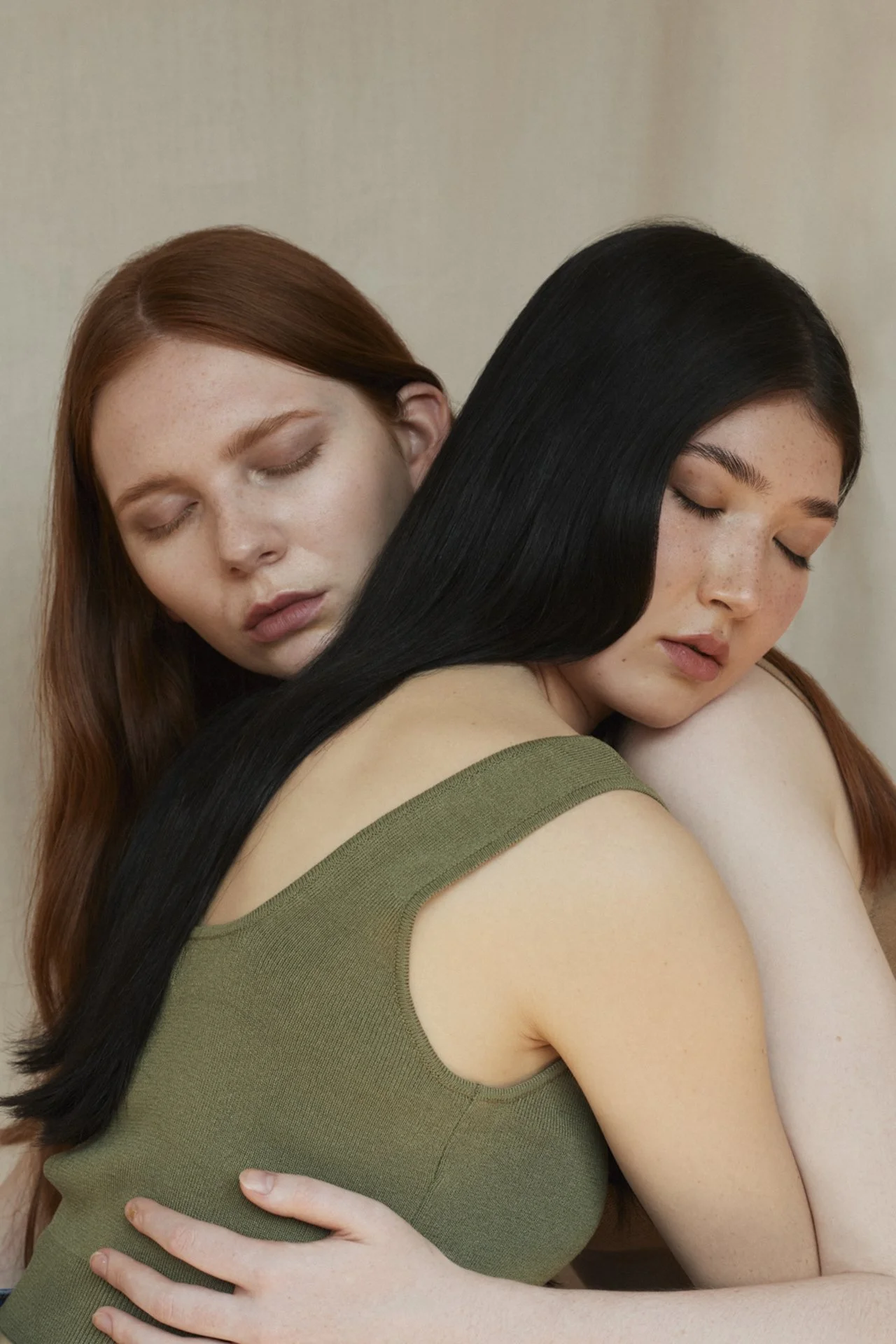 Zwei Frauen, die eng umarmt und mit geschlossenen Augen sind, in Nahaufnahme.