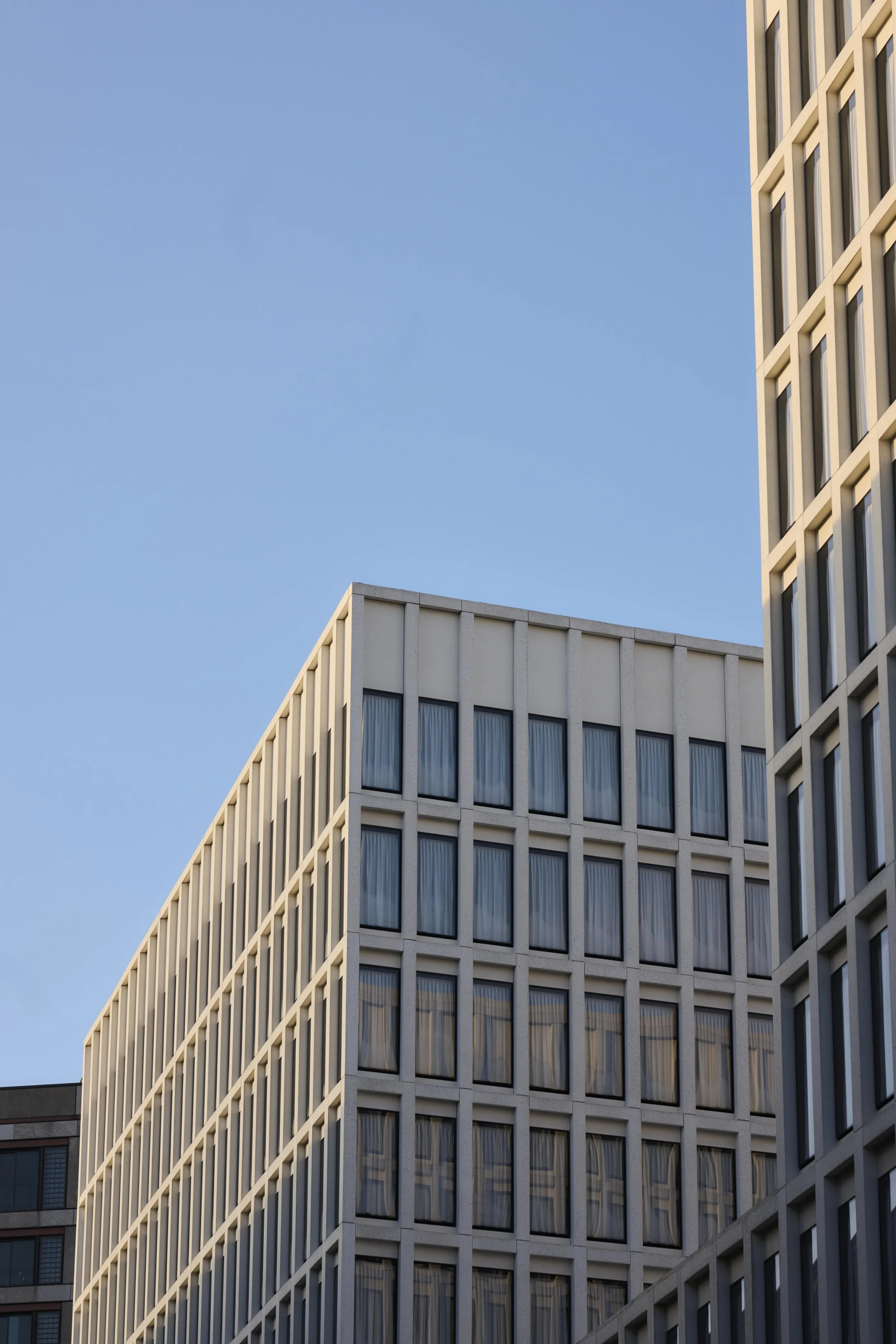 Hochhäuser mit modernen Fassaden gegen blauen Himmel, Blick nach oben.