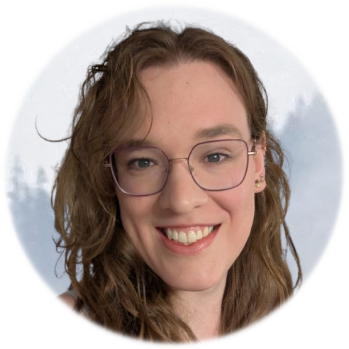 A woman smiling with wavy red hair, wearing glasses, in front of a cloudy sky background.