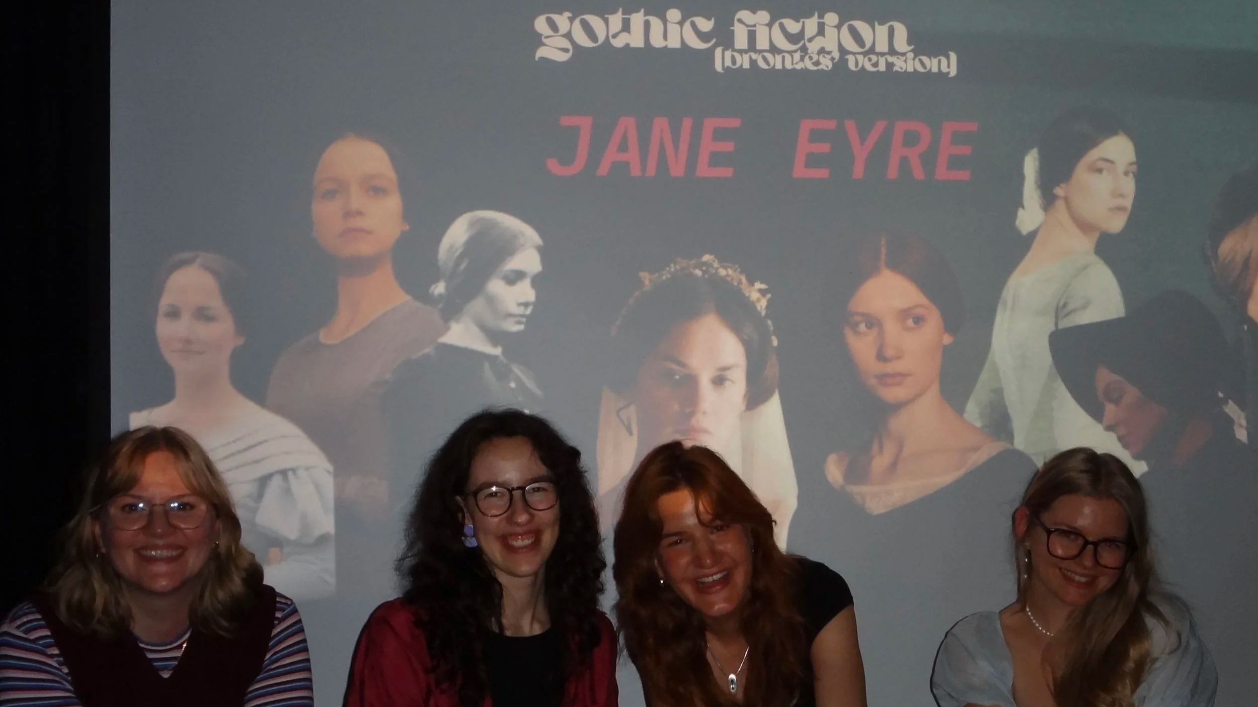 Die Zänkischen Littchen (Friederike Krüger, Cilly Pola Krämer, Verena Meyer und Helena Wilde) vor einem Bild aus ihrer Veranstaltungsreihe zu GOTHIC FICTION (brontës' version) mit verschiedenen Inszenierungen des Romans Jane Eyre
