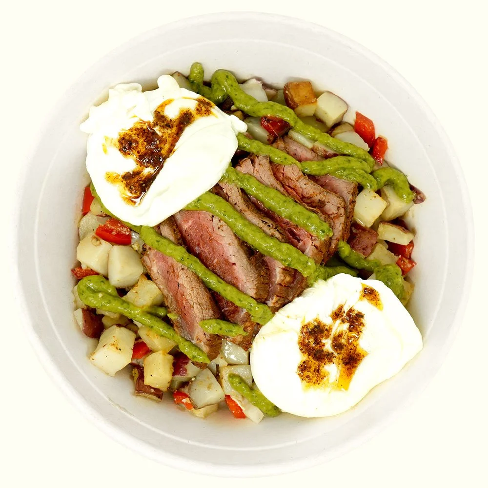 Steak & Egg Bowl - Grass fed steak, breakfast potatoes and two poached eggs, drizzled with caliente and avocado salsa.