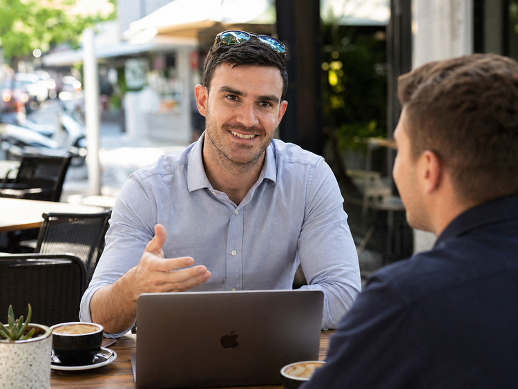 Dom in conversation with a small business owner at a café
