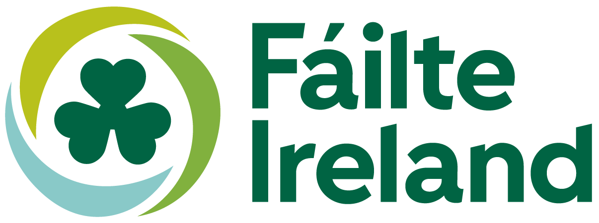 Logo for Fáilte Ireland, featuring a stylized shamrock surrounded by circular shapes in green, black, and light blue, with the text 'Fáilte Ireland' in green.