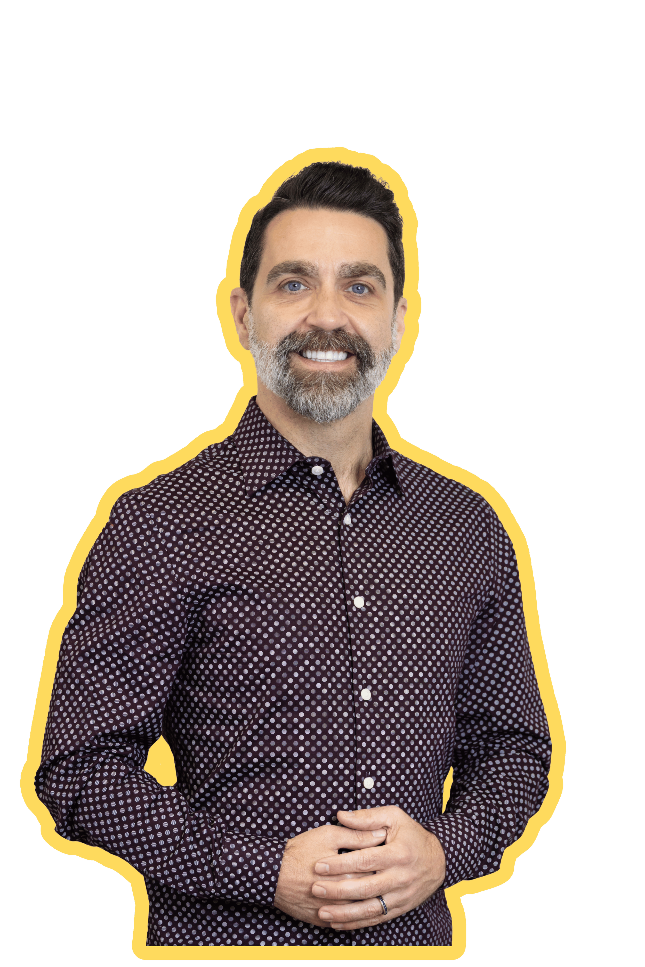A smiling man with dark hair, a beard, and blue eyes, wearing a long-sleeve shirt with a small polka dot pattern, against a black background with a yellow outline.