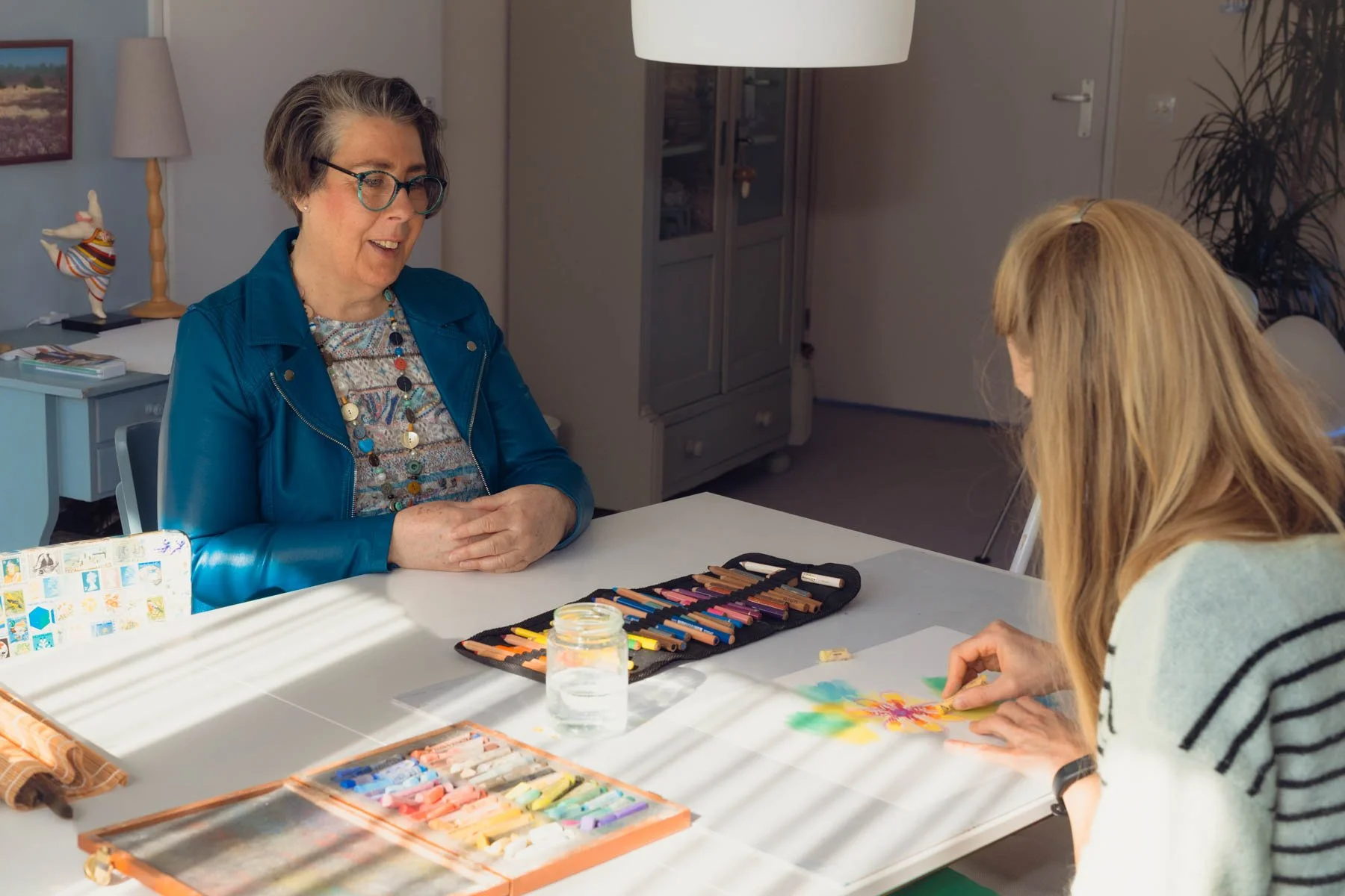 Karin Boodt in gesprek met een cliënt tijdens een beeldende therapie sessie.