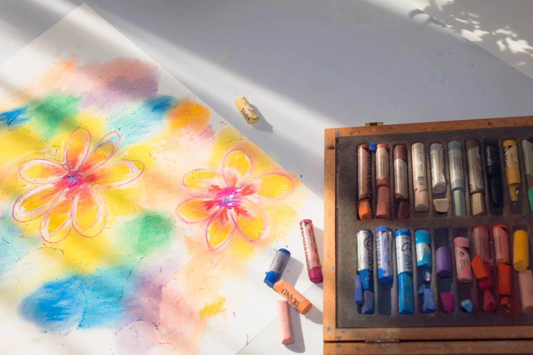 Kleurrijke bloementekening gemaakt met pastelkrijt tijdens beeldende therapie.