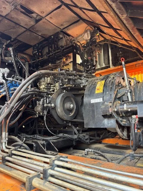 Vue intérieure d'un moteur de machine lourde avec divers composants, câbles et tuyaux.