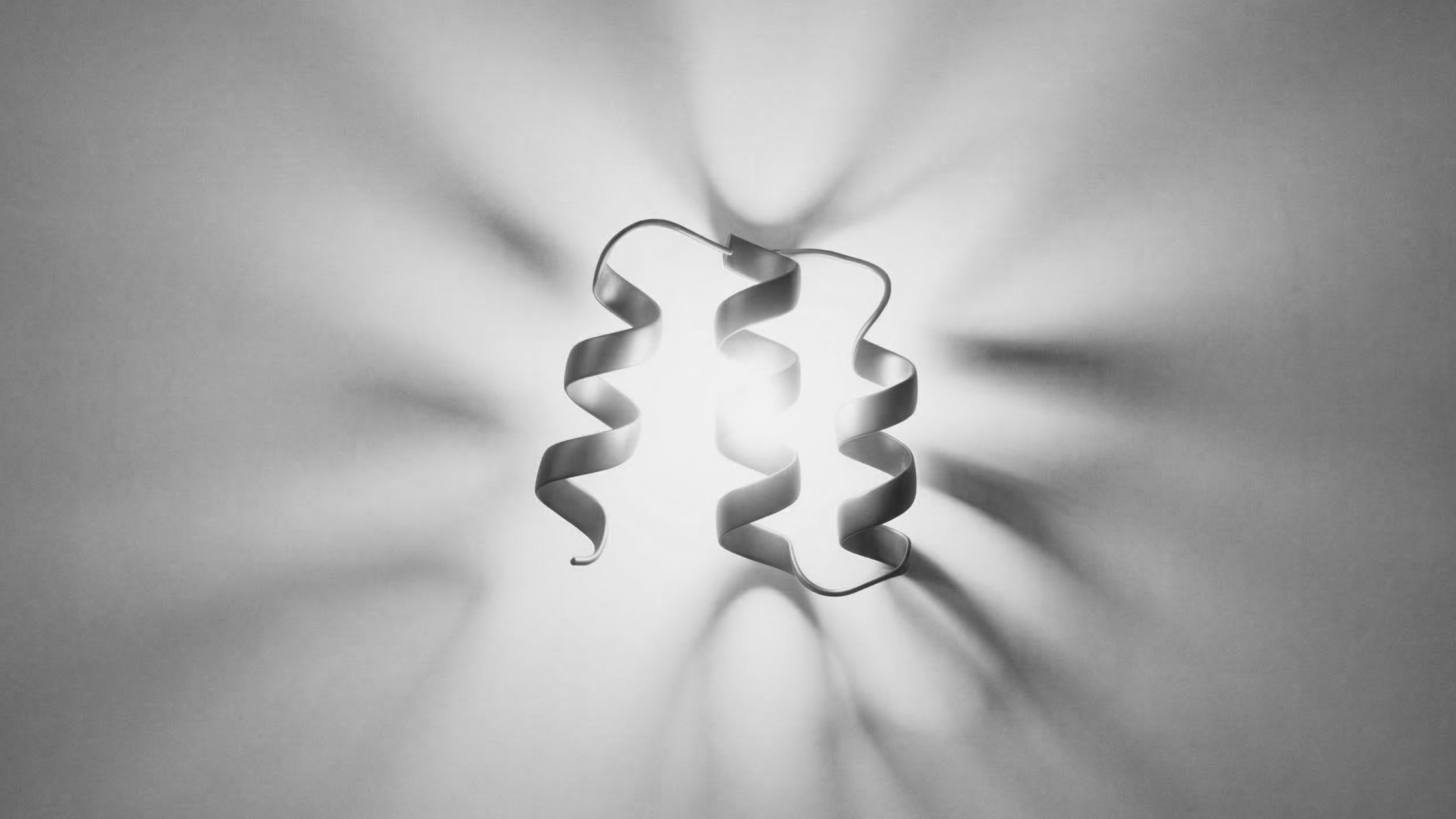 A spiraled metal object casting shadows on a wall, illuminated from behind.