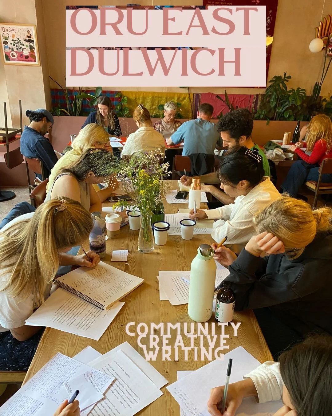 People gathered around a wooden table, engaged in community creative writing, with papers, notebooks, and drinks, in a cozy cafe setting with plants and a large sign that reads "ORU EAST DULWICH" in the background. The words "COMMUNITY CREATIVE WRITING" are overlaid at the bottom.
