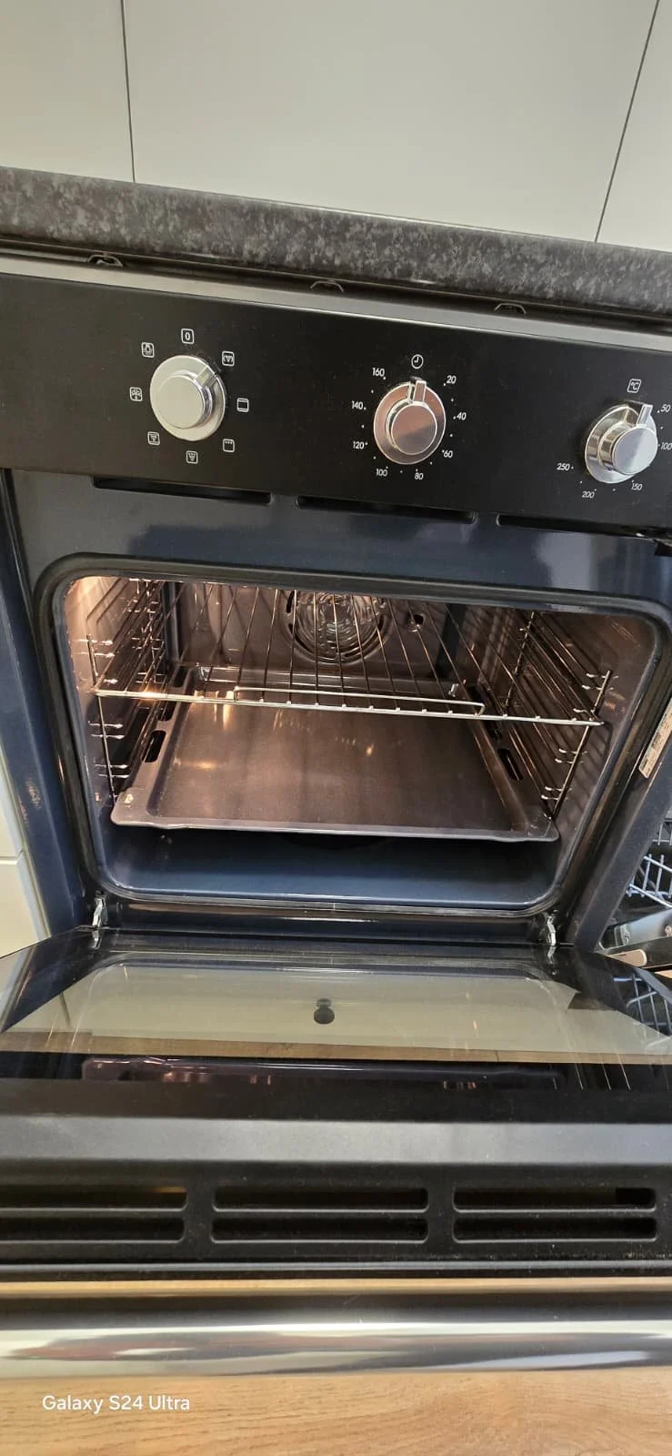 Een elektrische oven met het deurtje open, geen objecten in de ovenruimte, beschikbaar op een keukenblad.