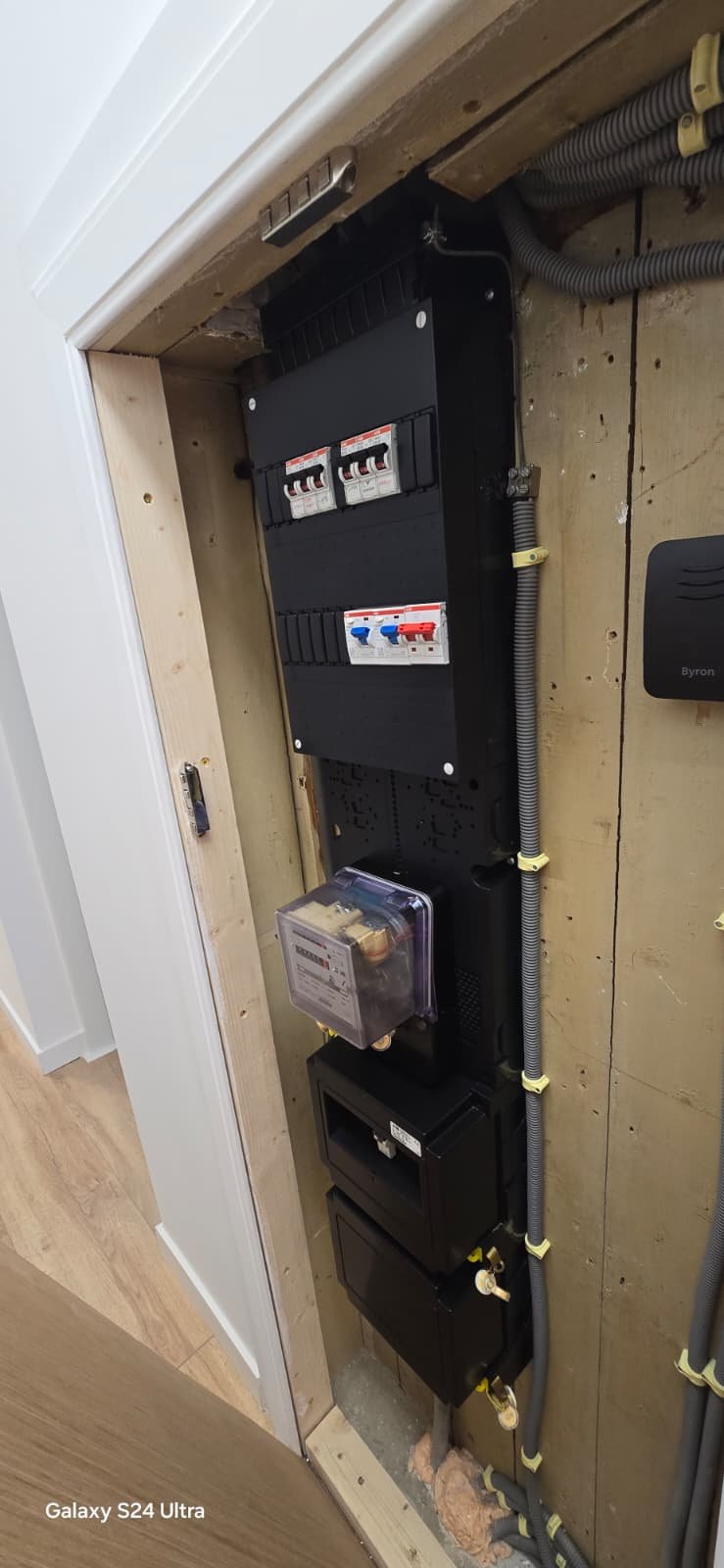 Elektriciteitskast met schakelaars, meter en kabelgoten in een bouwconstructie