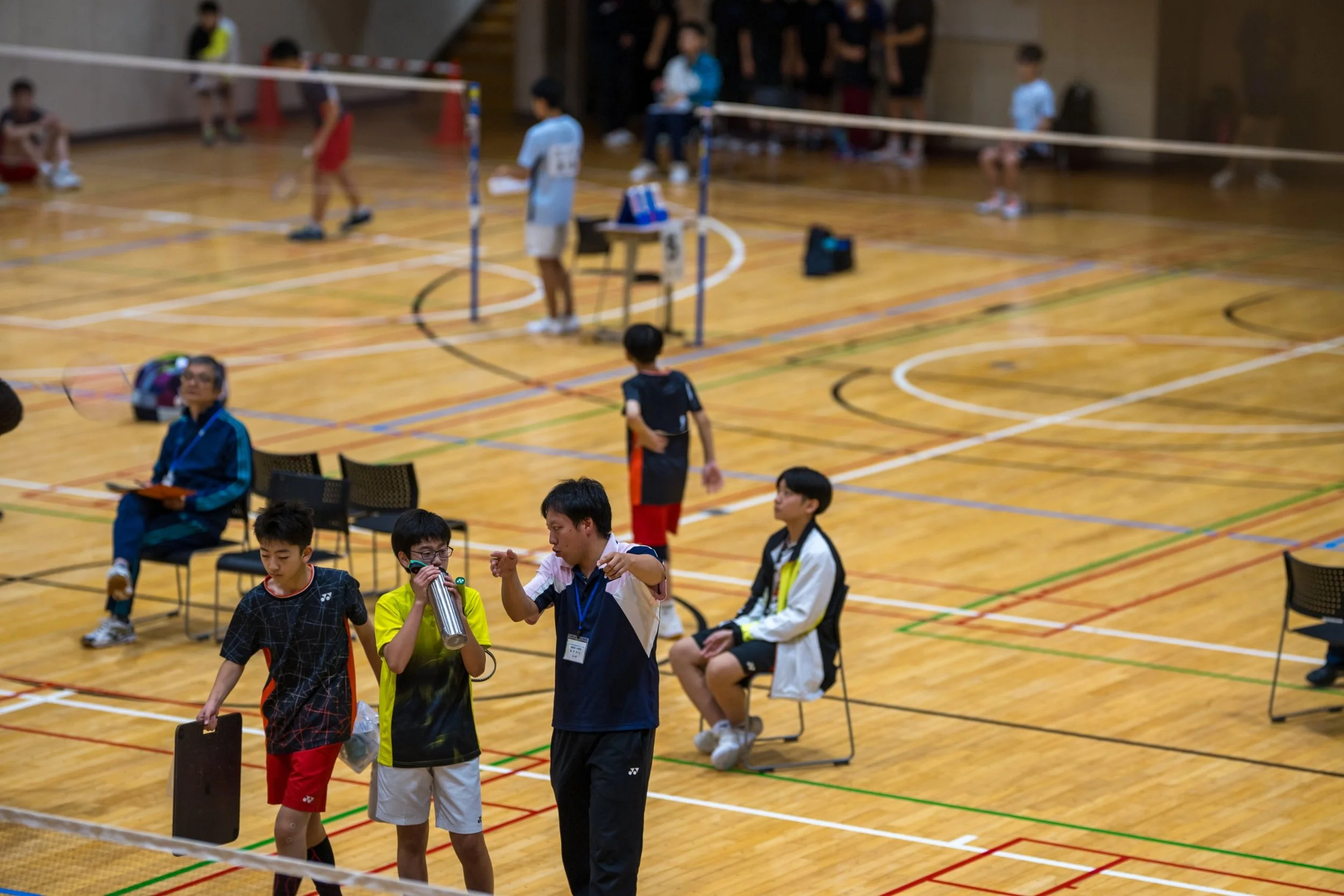 田川地区新人戦2026 バドミントン 水分補給をしながらコーチの指示を聞く選手