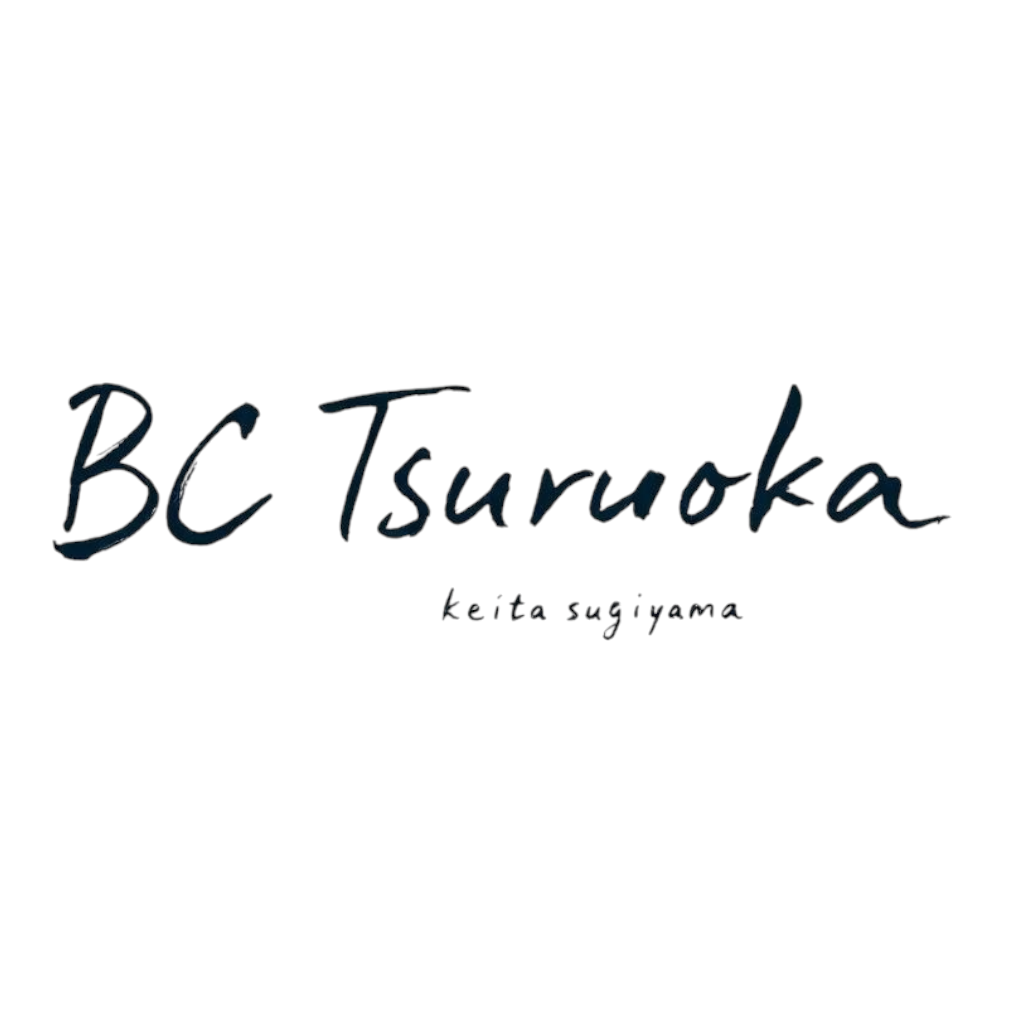 黒い背景に、ピンクと白の文字で書かれたイラストと、青い手書きの文字で『BC Tsuruoka』と書かれているロゴ