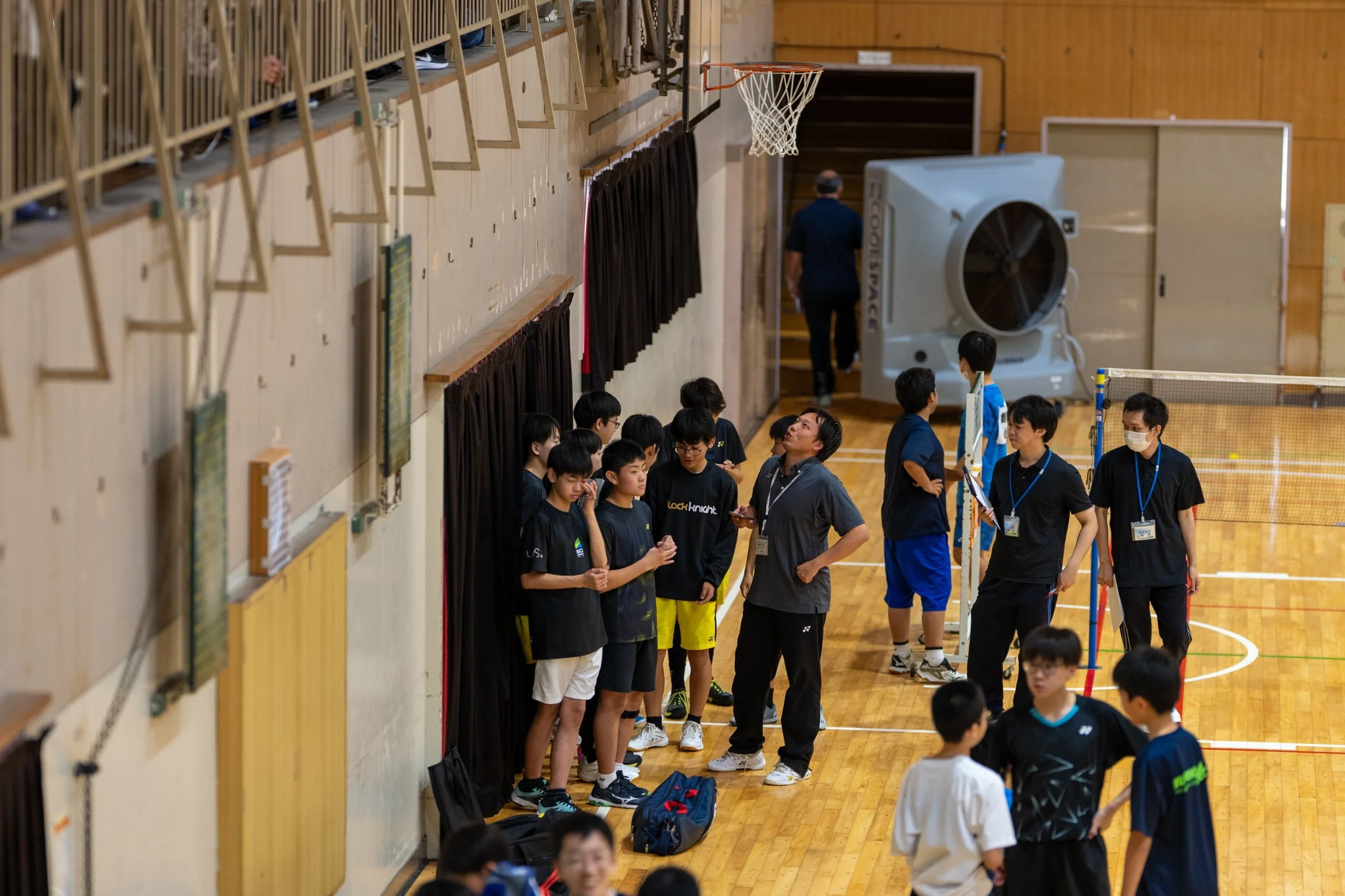 田川地区新人戦2026 バドミントン 試合の合間に集まる選手とコーチ