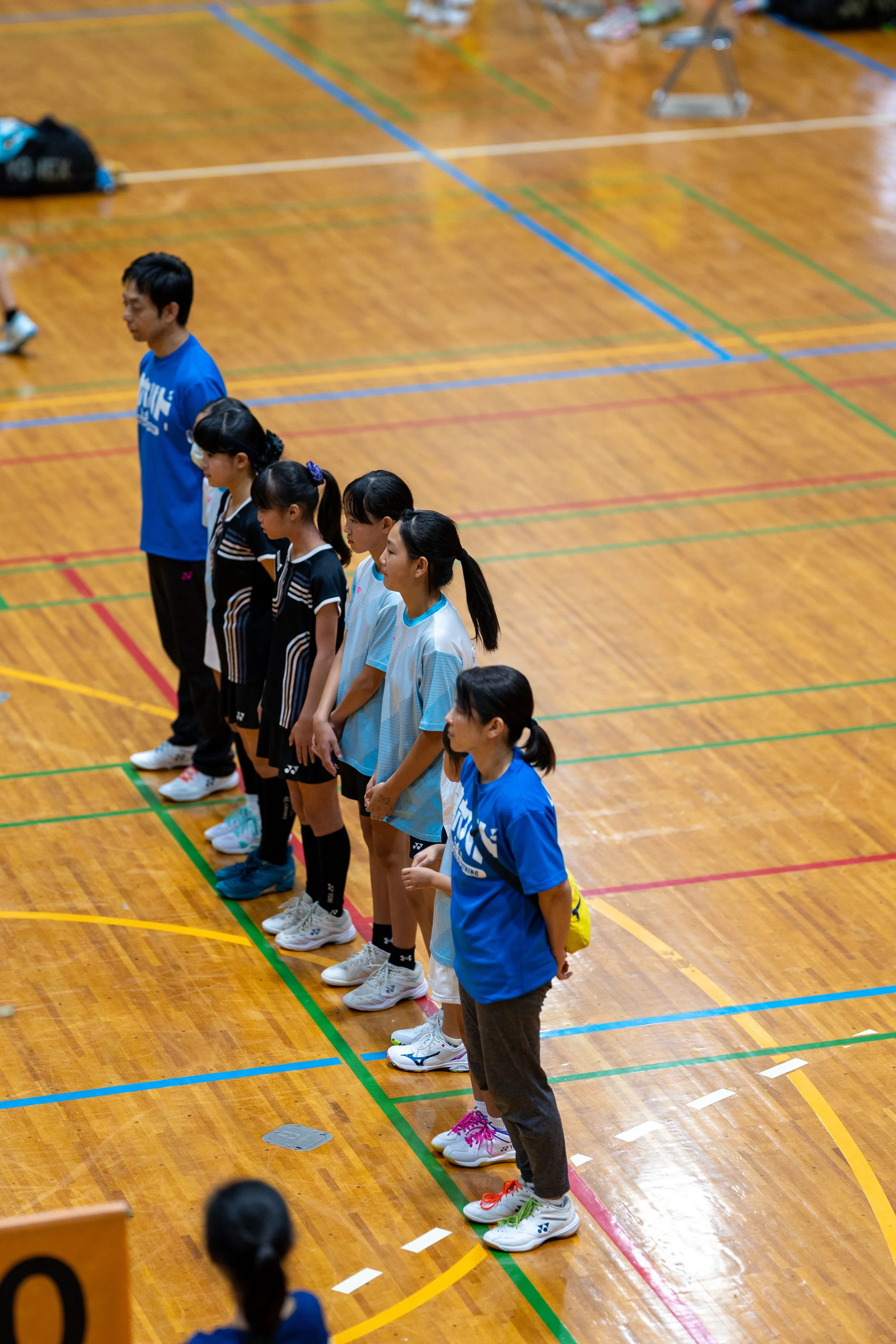 コートの線に一列に並ぶ鶴六の選手とコーチ｜第34回山形県少年少女スポーツ交流大会（新庄市体育館）