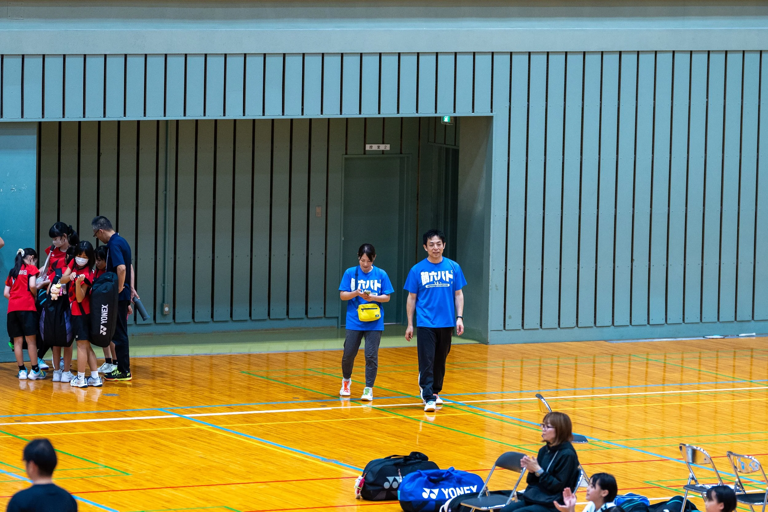体育館を歩く鶴六バドのスタッフ｜第34回山形県少年少女スポーツ交流大会