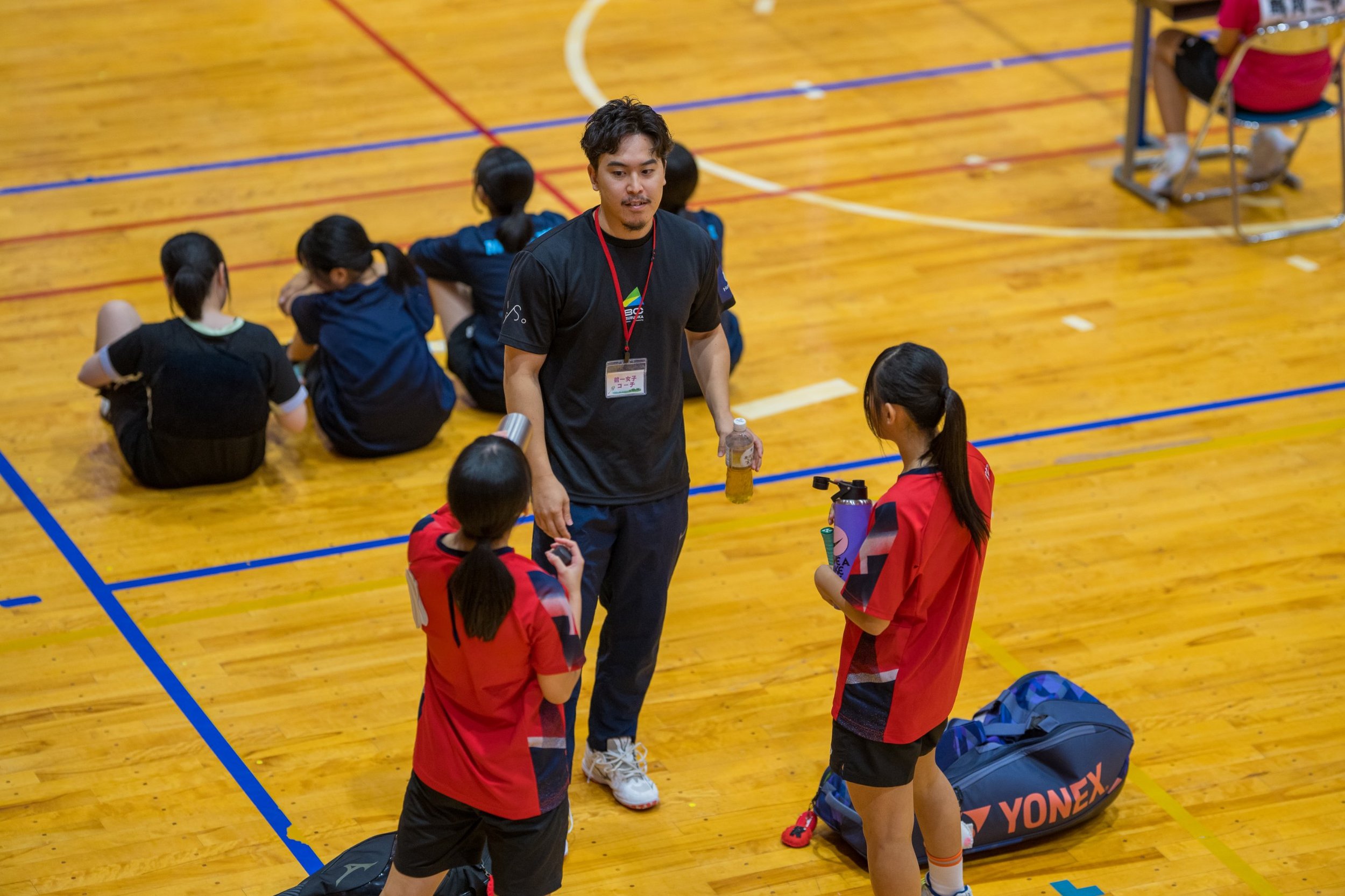 田川地区新人戦2026 バドミントン 試合の合間にコーチの話を聞く選手たち