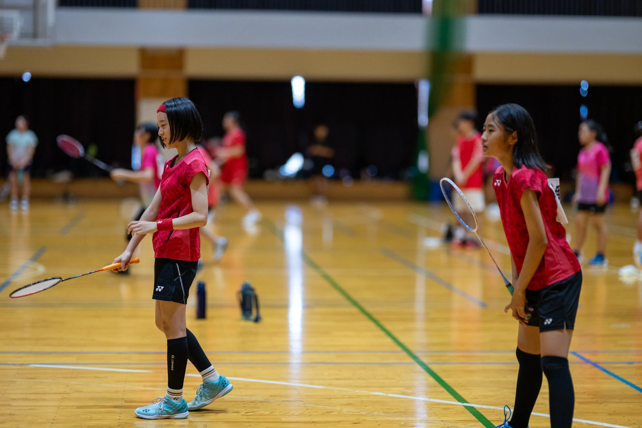 体育館でバドミントンをしている女子学生たち。