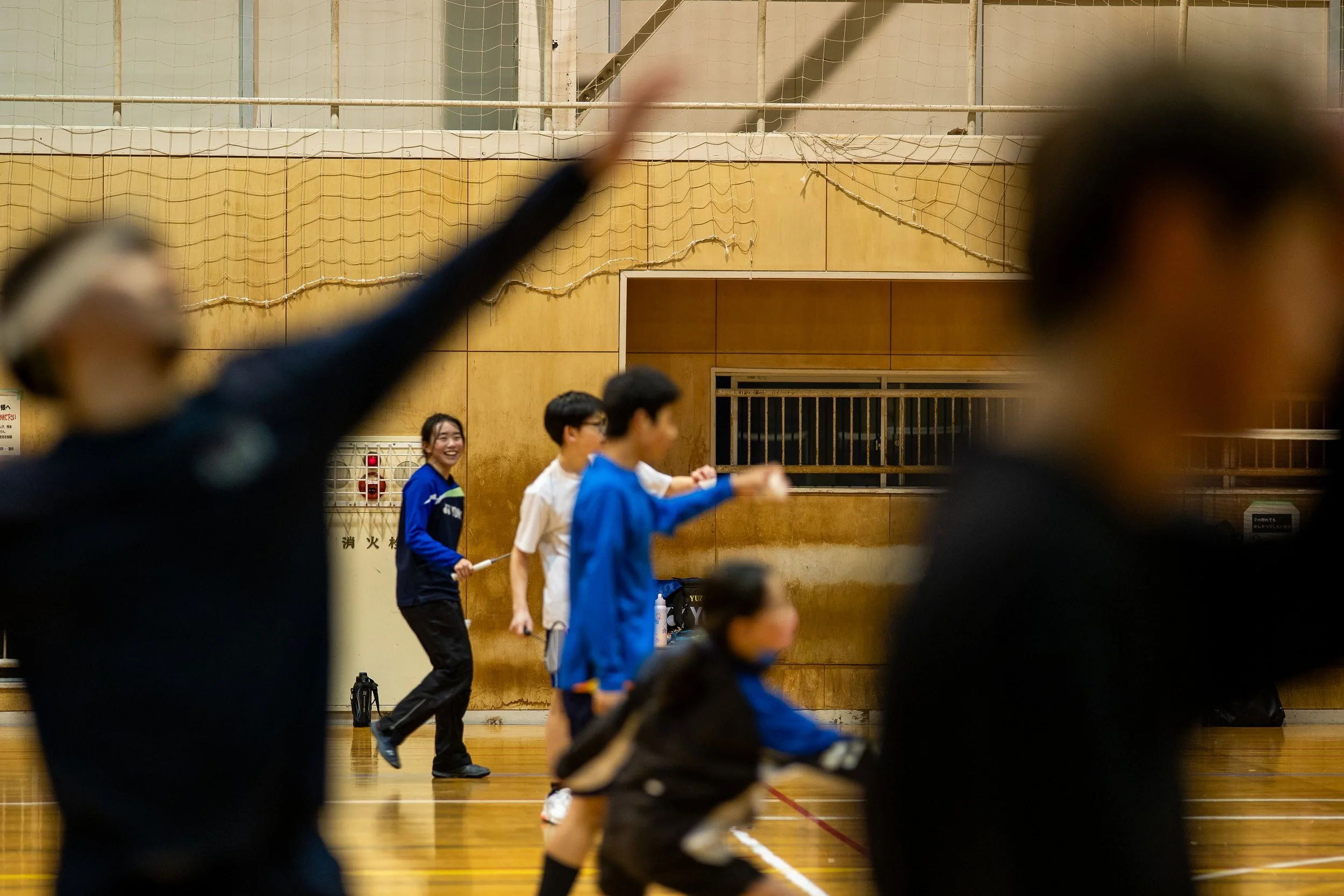 体育館でバレエ練習をする少年少女のグループとコーチ