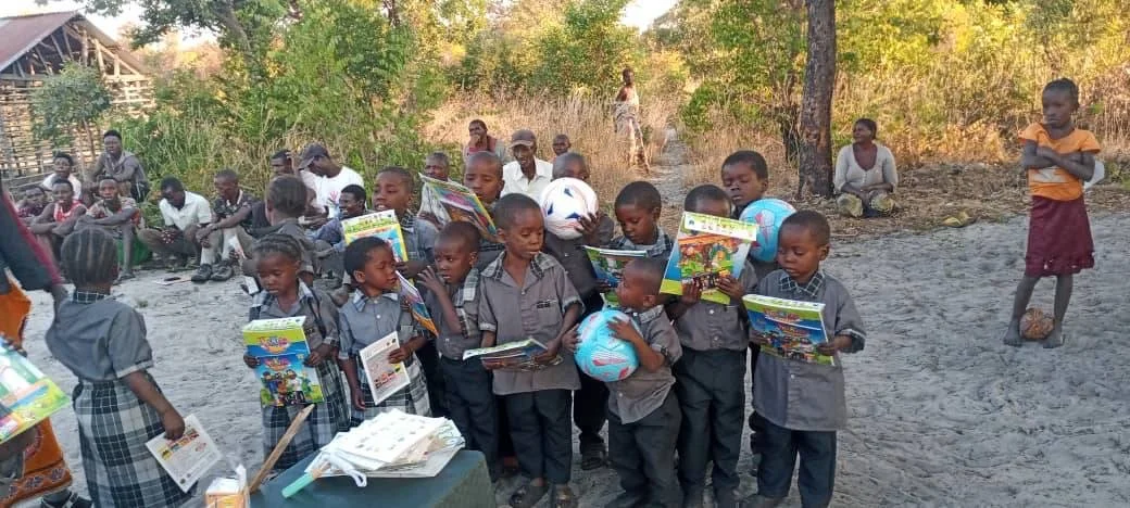 Group of children in school uniforms reading books outdoors