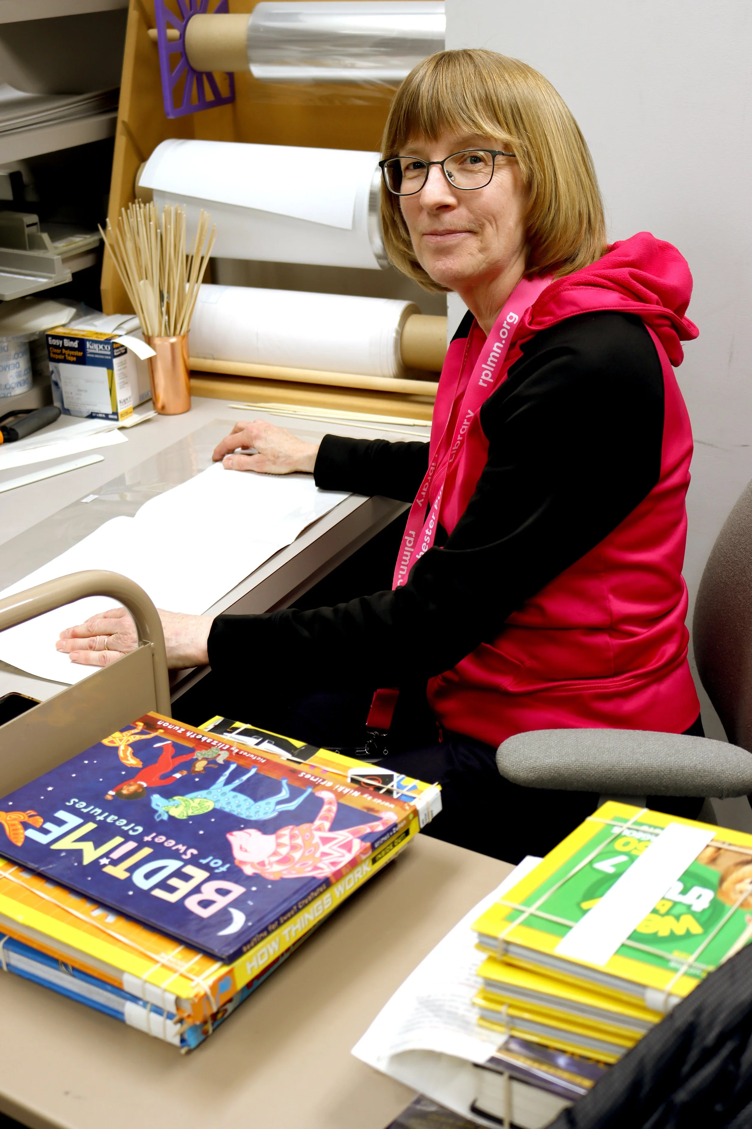 A library volunteer prepares a book to be added to the collection.